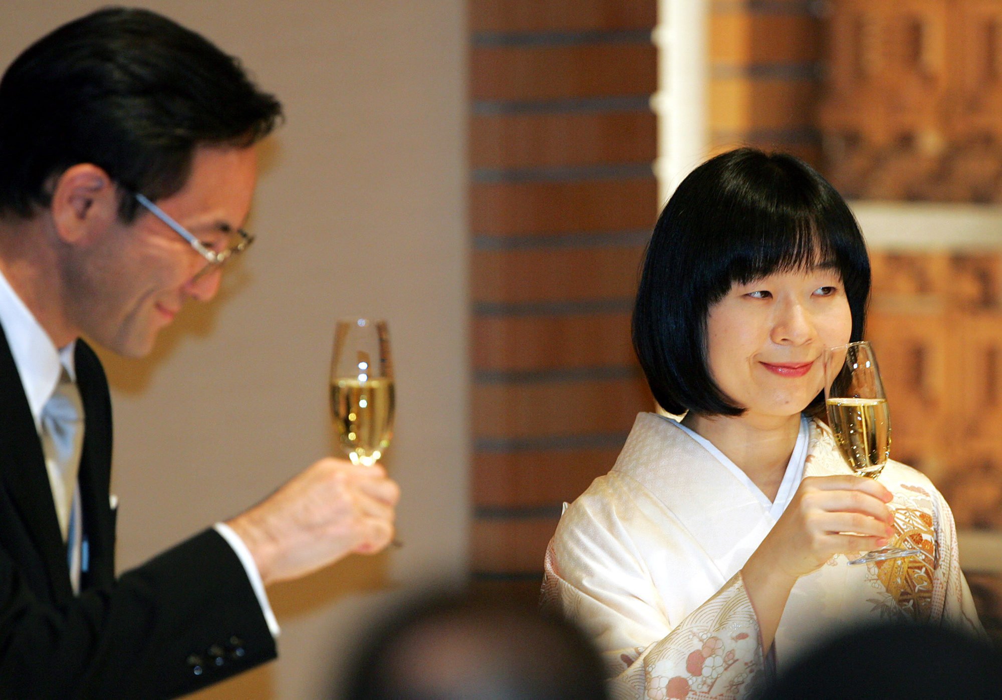 Sayako Kuroda and her husband Yoshiki Kuroda raise glasses of champagne during their wedding banquet at a Tokyo hotel in November 2005. Photo: AP Photo