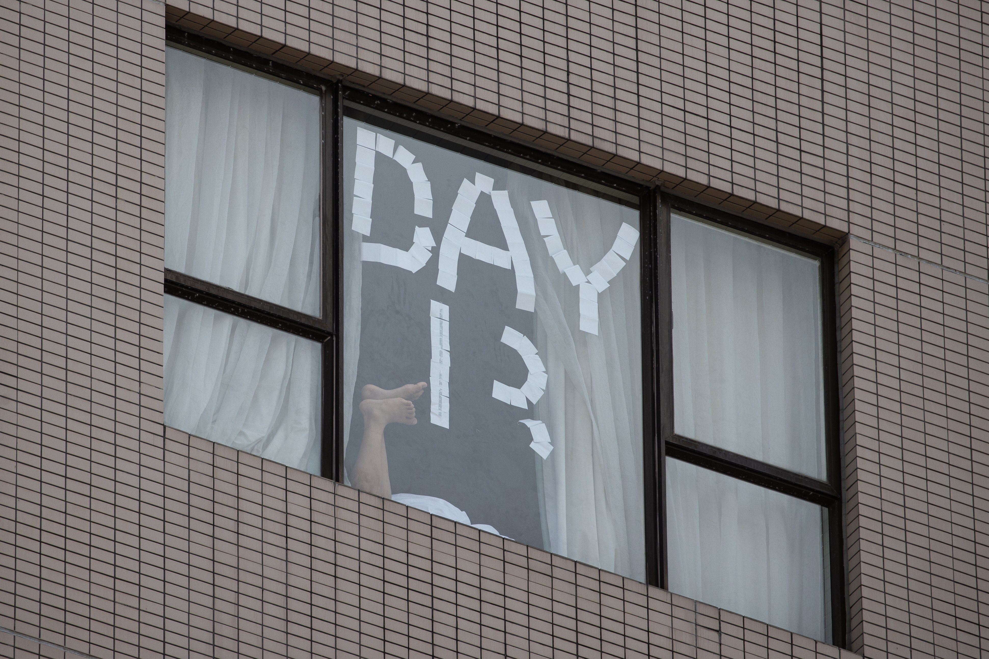 A person’s feet can be seen through the window of a government-designated quarantine hotel in Hong Kong. Photo: EPA