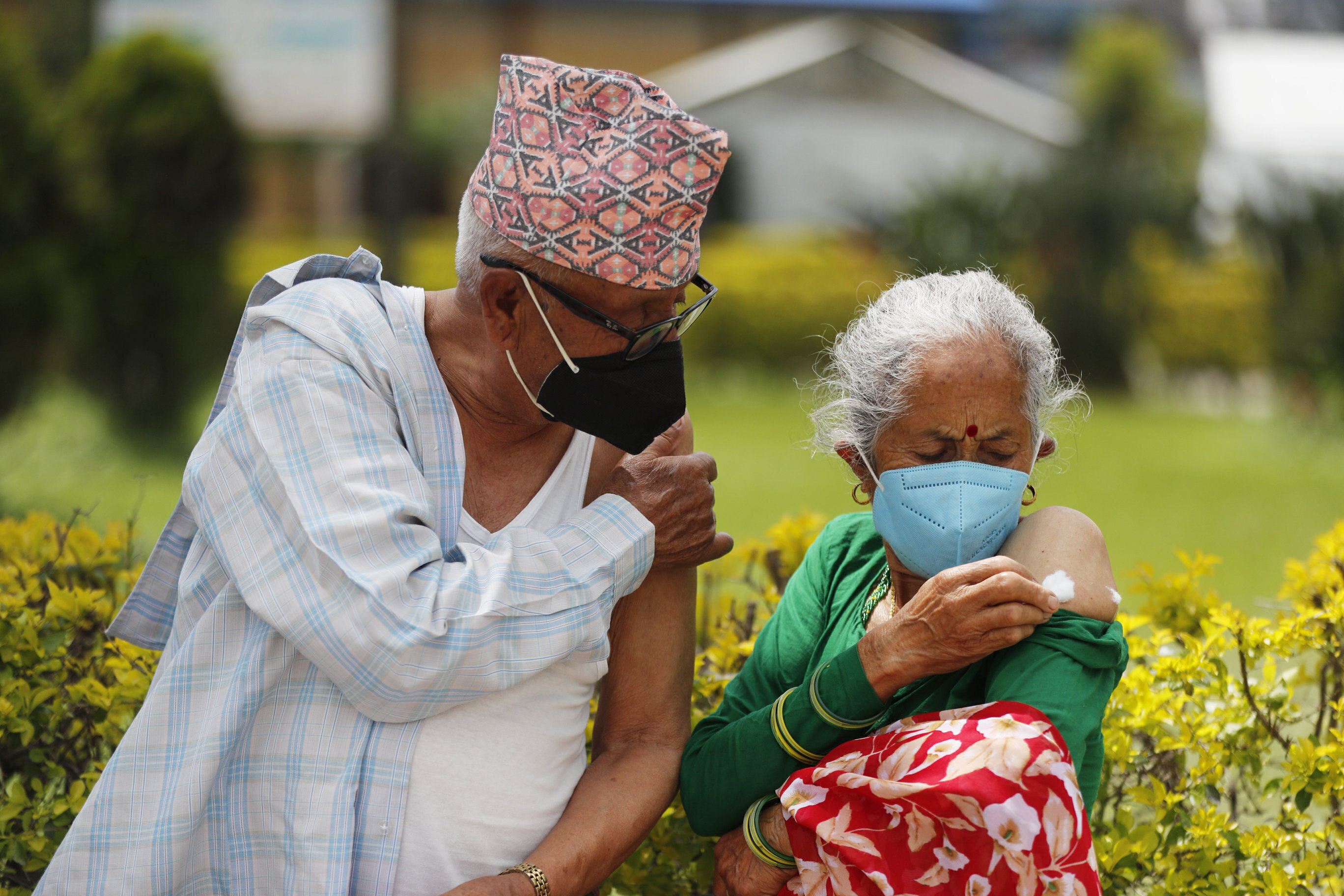 An elderly Nepalese couple wait outside after receiving a Covid-19 vaccine in Kathmandu, Nepal, on August 9. Photo: AP