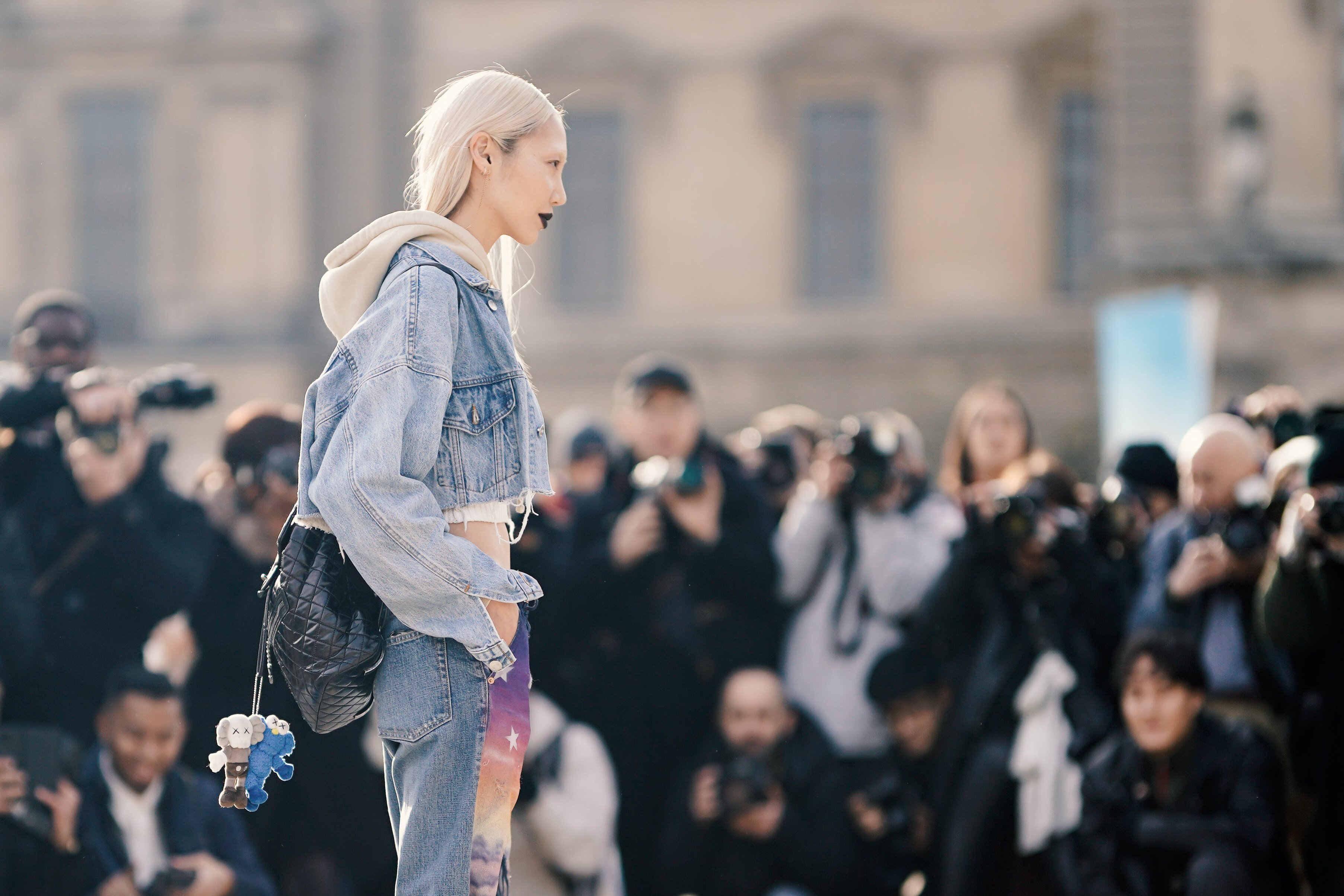 Soo Joo Park wears a blue denim jacket, a cropped hoodie sweater, a white cropped top, purple “Europe” pants outside Off-White during Paris Fashion Week in  Paris, France. Photo: Getty Images
