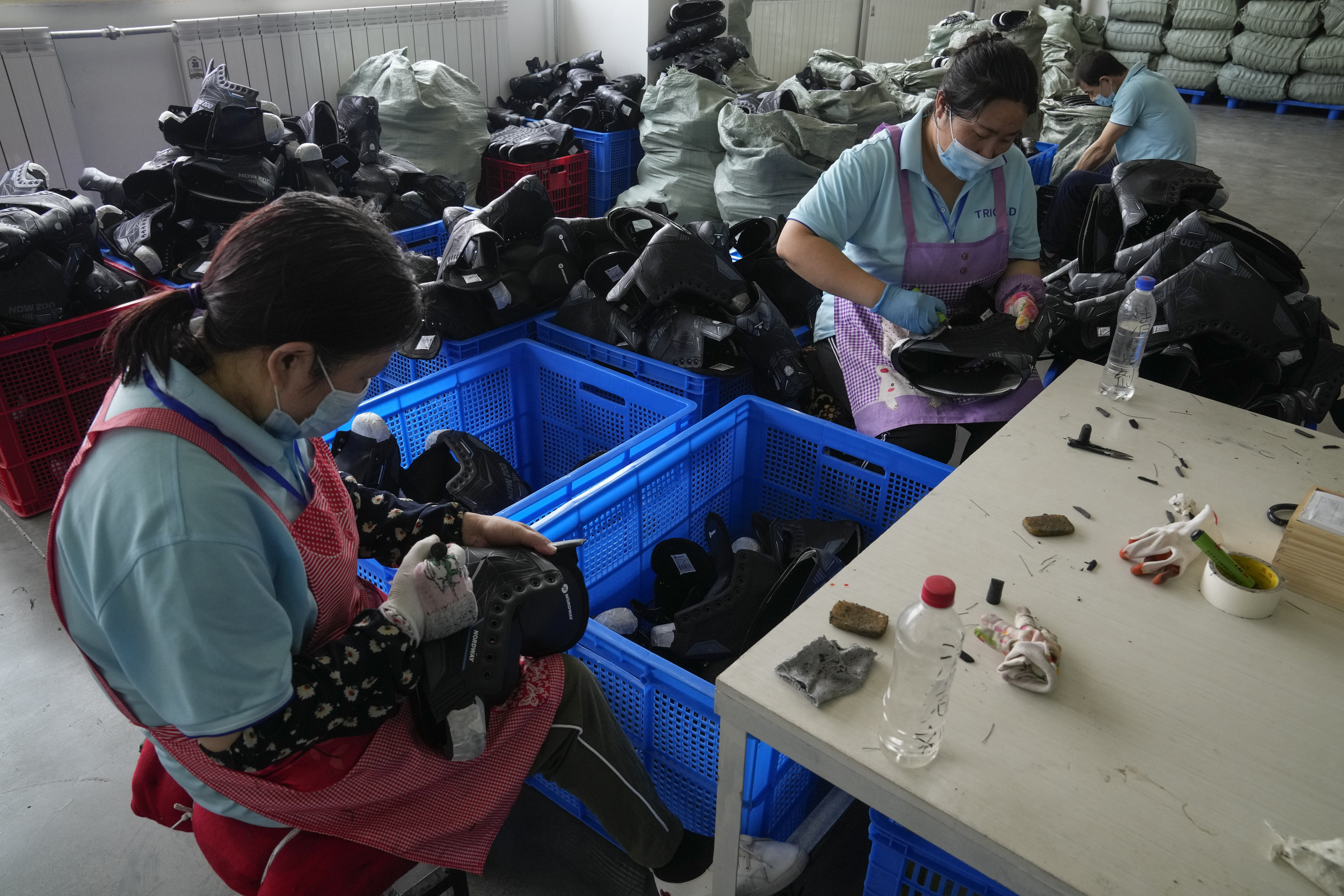 Workers assemble ice skates at a factory in Zhangjiakou, in northwestern China’s Hebei province, on July 15. China’s retail sales and industrial production growth weakened in July as floods and Covid-19 outbreaks disrupted consumption and supply chains. Photo: AP