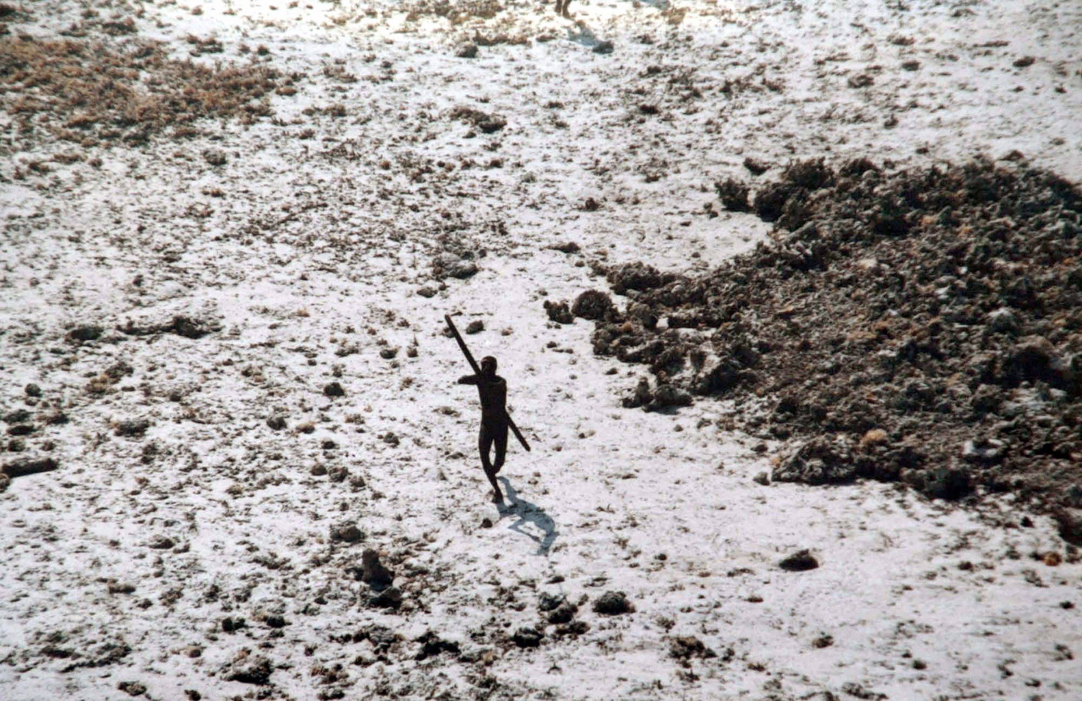 A man with the Sentinelese tribe aims his bow and arrow at an Indian Coast Guard helicopter as it flies over North Sentinel Island in the Andaman Islands. Hong Kong sailors feared attack when their ship ran aground there in 1981. Photo: AFP/Indian Coast Guard/Survival International