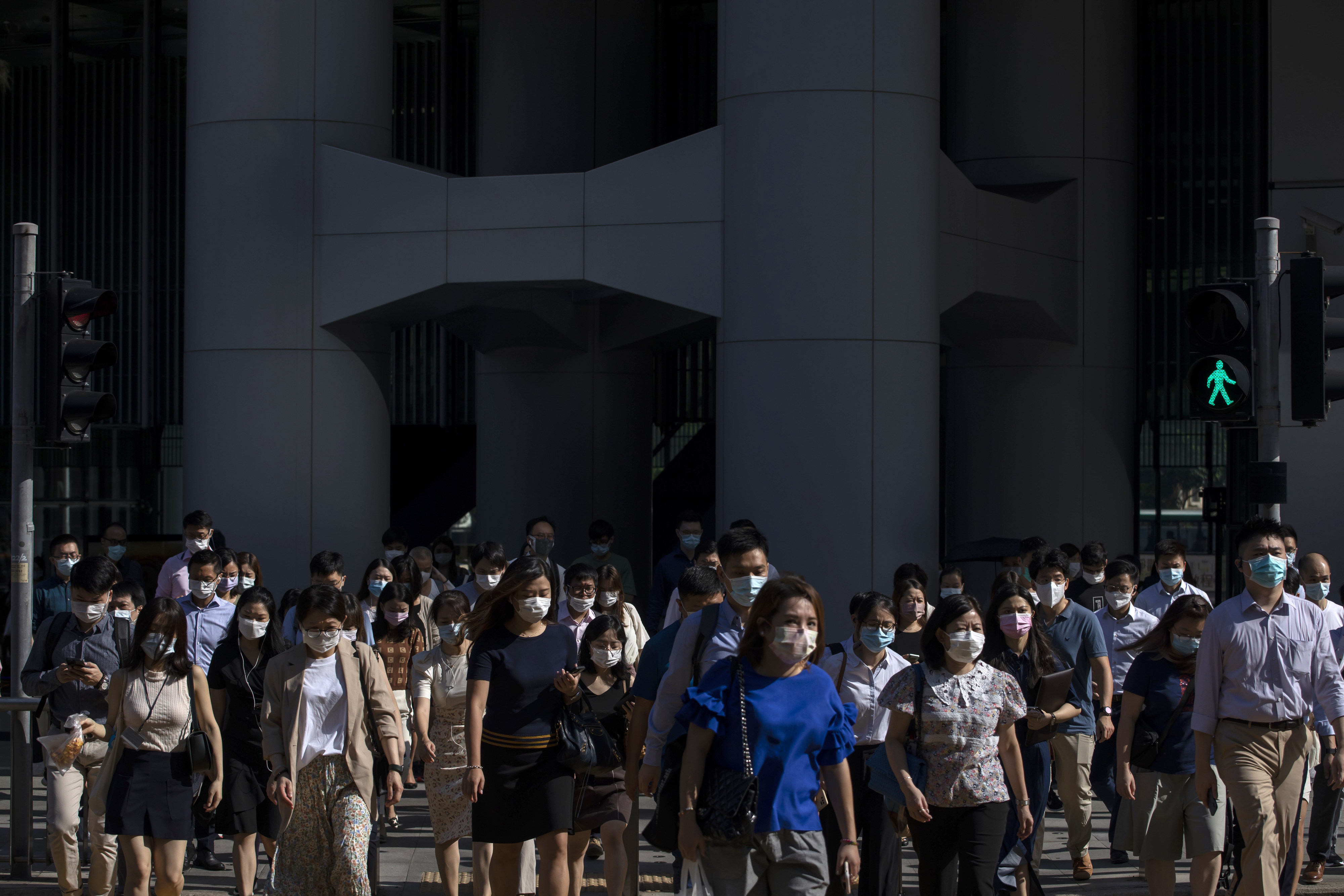 Morning commuters cross a street in Hong Kong’s Central district on August 18. Many women reach the height of their career and leadership capability at the same time that they enter perimenopause and menopause. Photo: Bloomberg