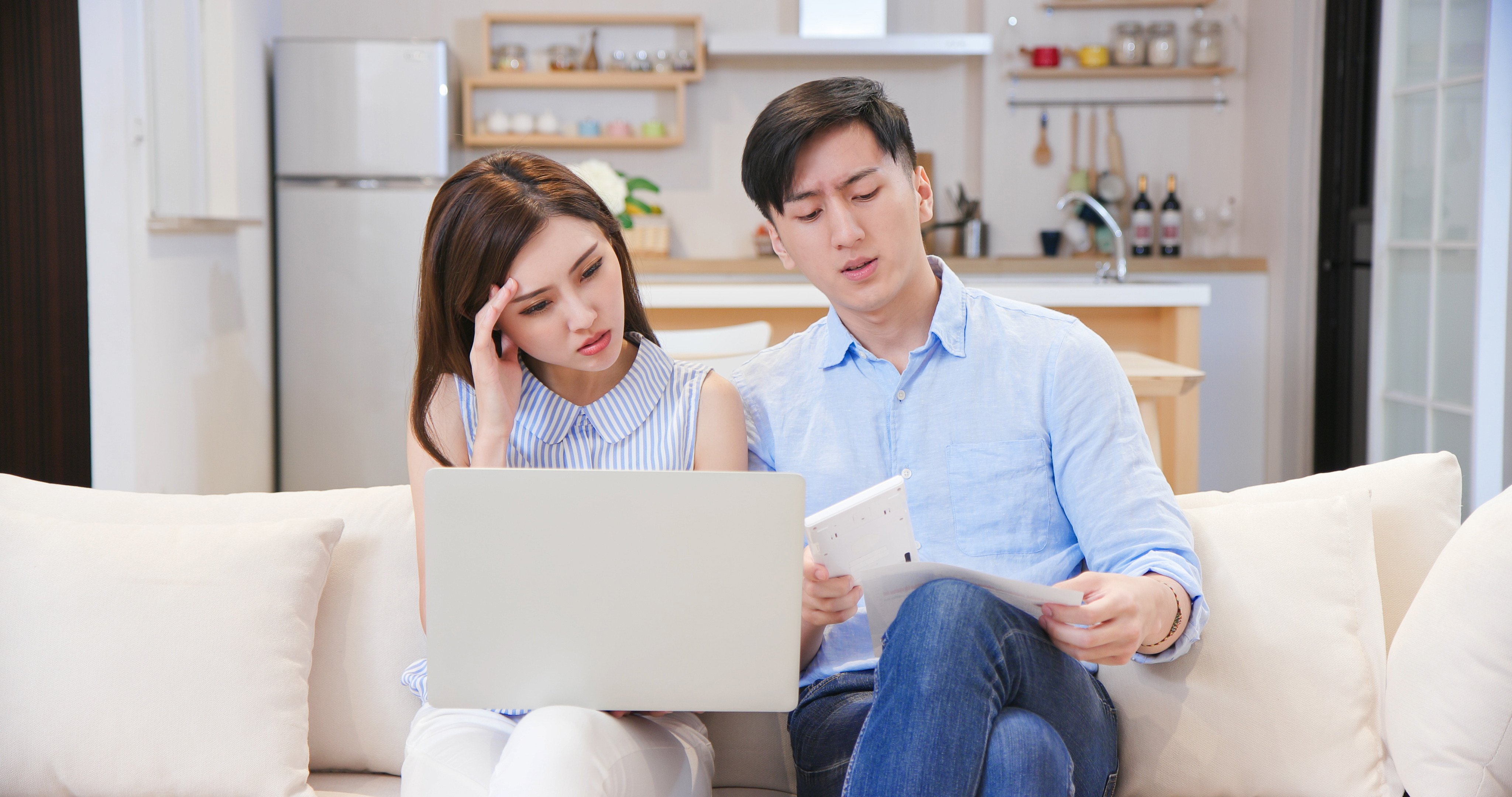 asian young couple calculate expenses finance with laptop and they have some argument at home.  CREDIT: Shutterstock