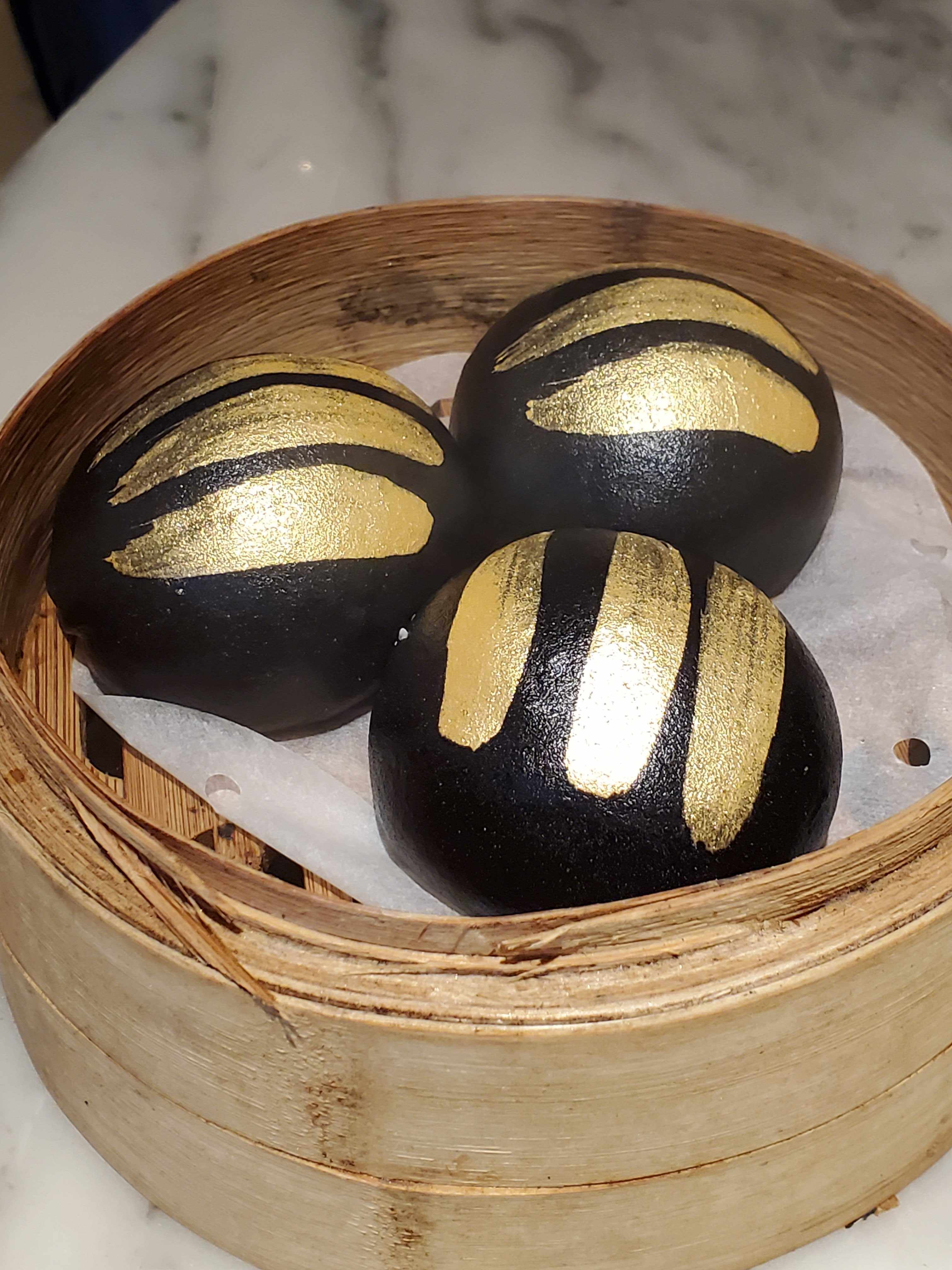 Charcoal custard buns with gold brushed over the top at modern dim sum restaurant Social Place in Central, Hong Kong. Photo: Ginny Wong