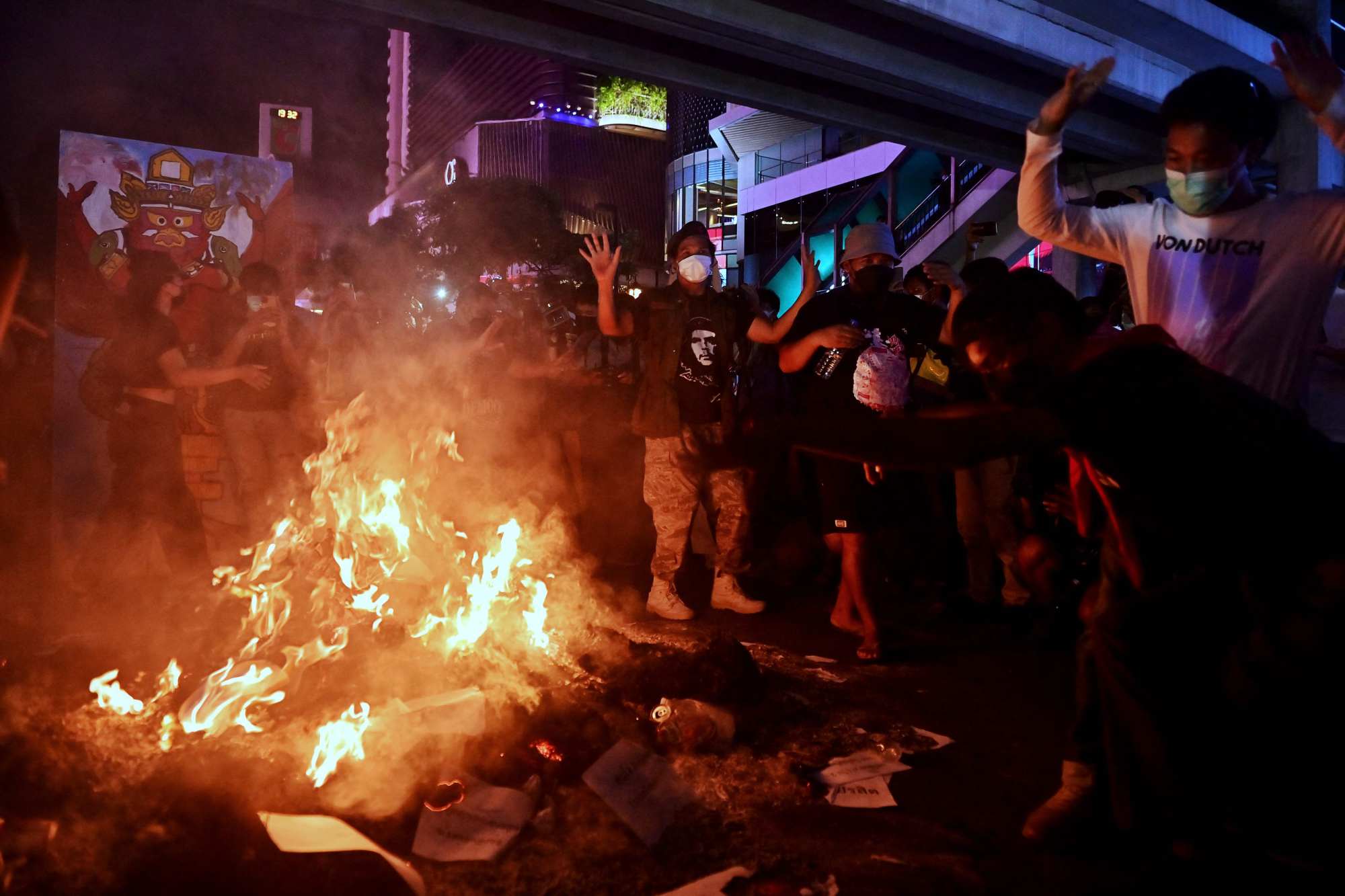 Protesters dance around a fire during a demonstration calling for the resignation of Thailand’s Prime Minister Prayuth Chan-Ocha over the government’s handling of the Covid-19 pandemic. Photo: AFP