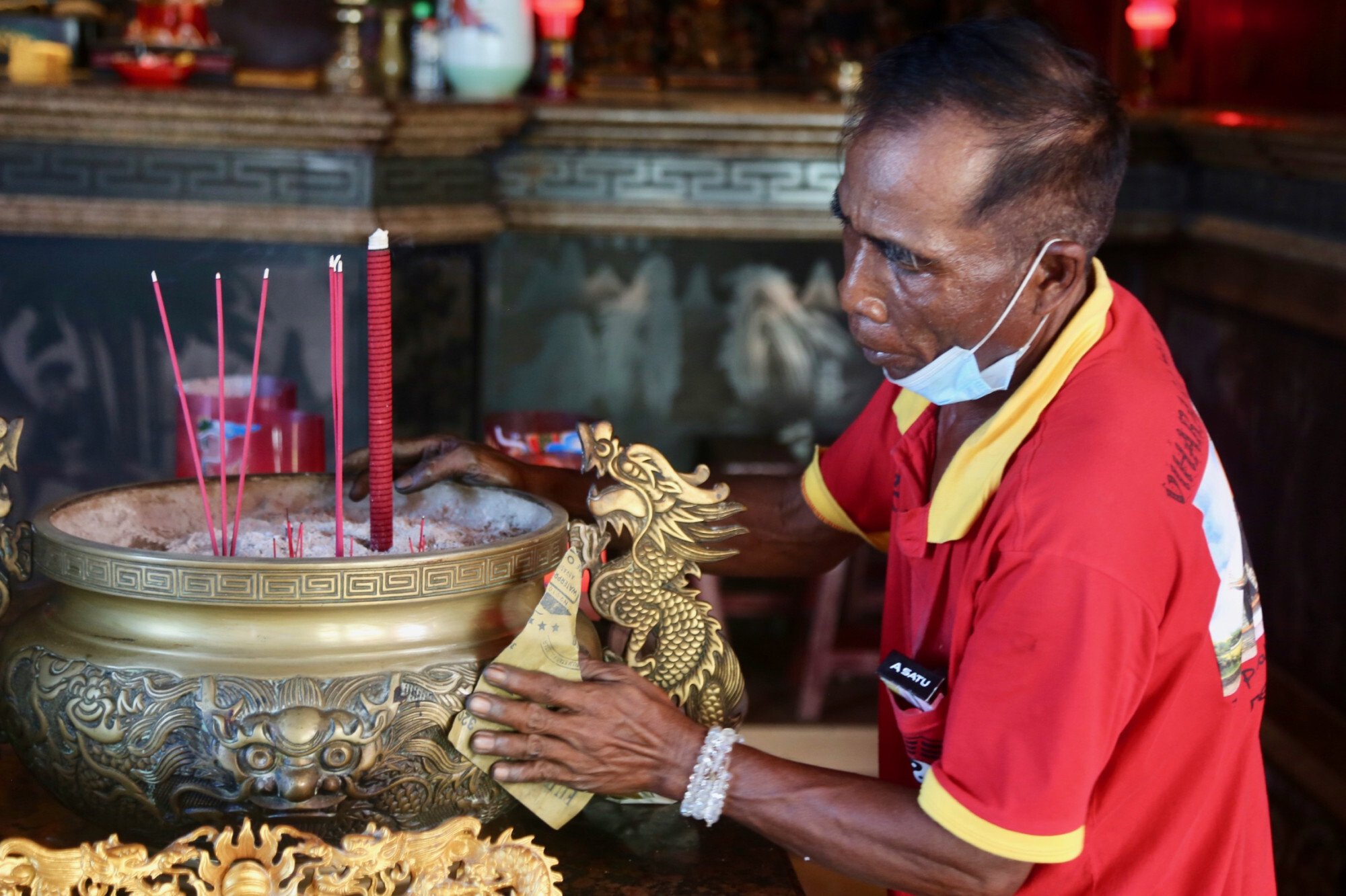 A worker polishes a gilded bowl at Vihara Satya Dharma. Photo: Ian Lloyd Neubauer