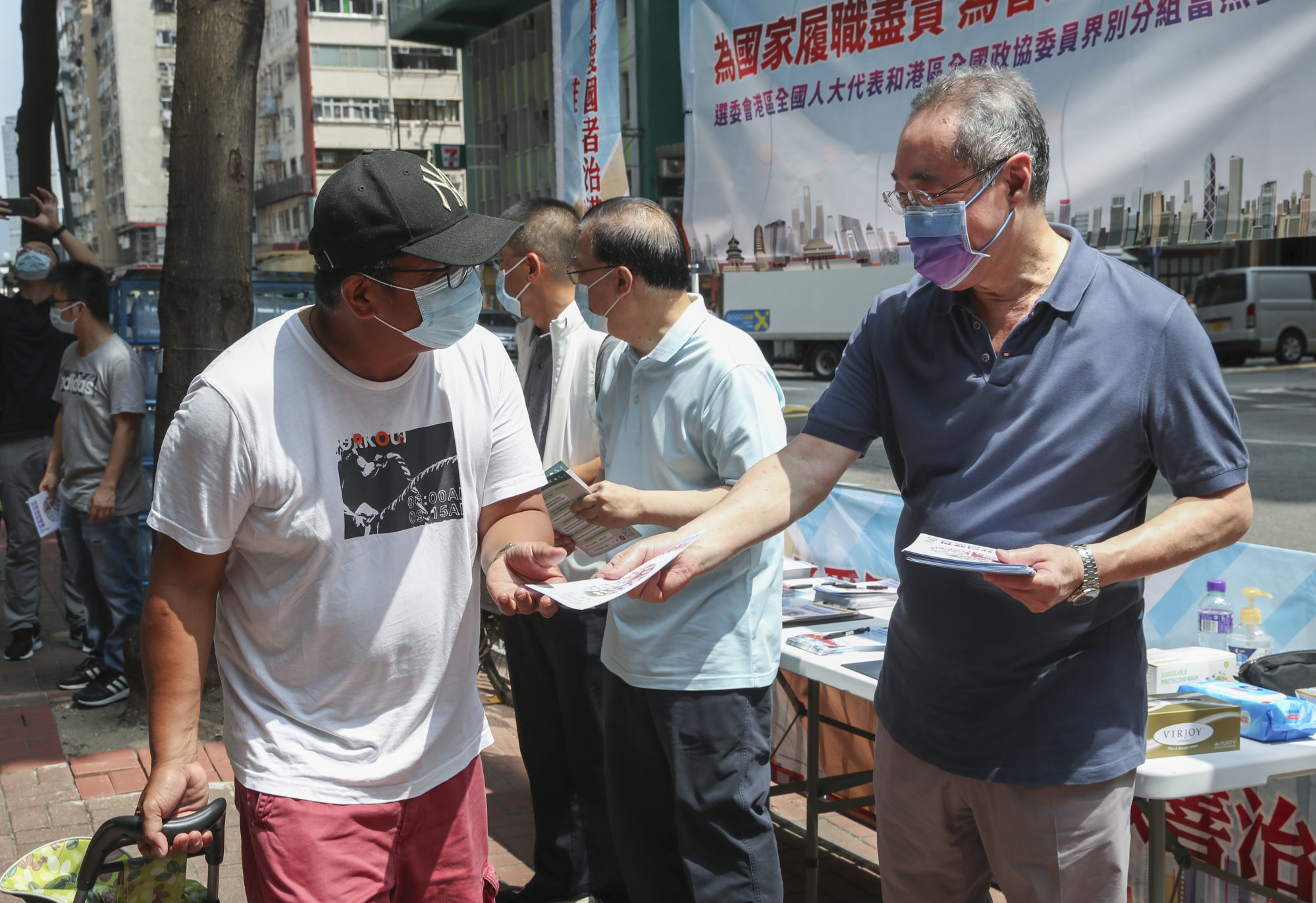 National People’s Congress Standing Committee member Tam Yiu-chung (second right) and politician Henry Tang Ying-yen (right) give out pamphlets to the public ahead of the Election Committee elections outside Tai Yau shopping mall in Wan Chai on September 11. Photo: Edmond So