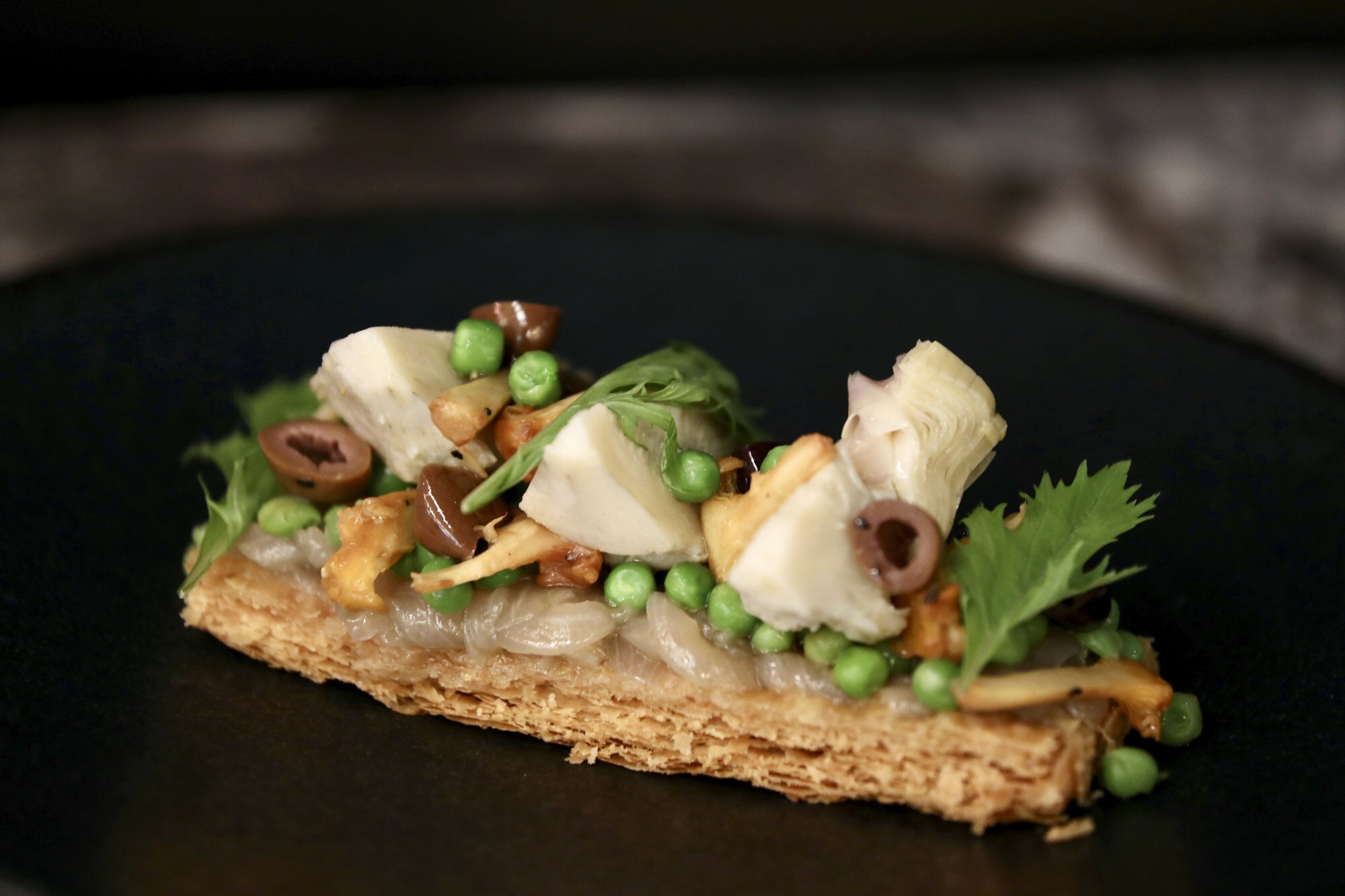 Tarte fine of sweet onions, girolles, peas and argan oil. Photo: Jonathan Wong