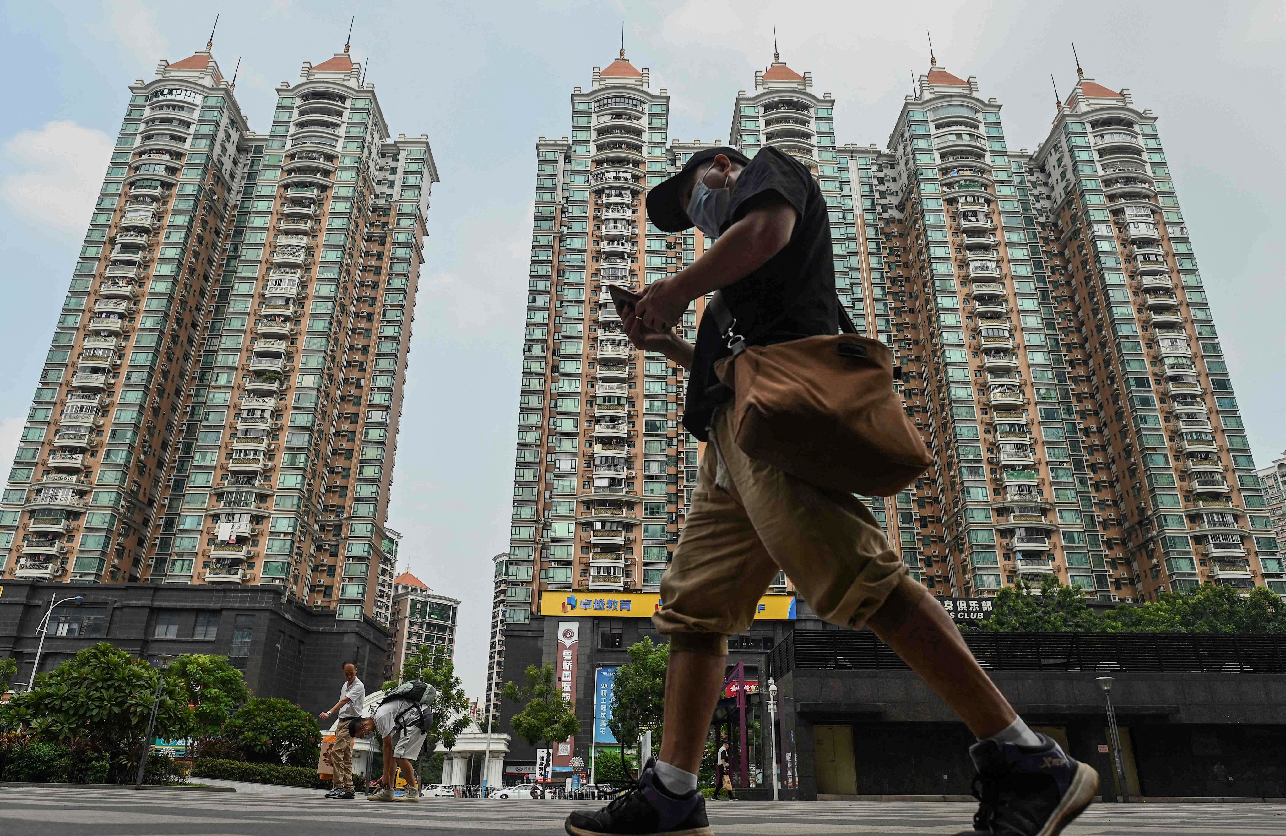 A man walks past a housing complex by Chinese property developer Evergrande in Guangzhou on September 17. The current problems in China’s real estate sector have only added to the pressure on Chinese equities. Photo: AFP