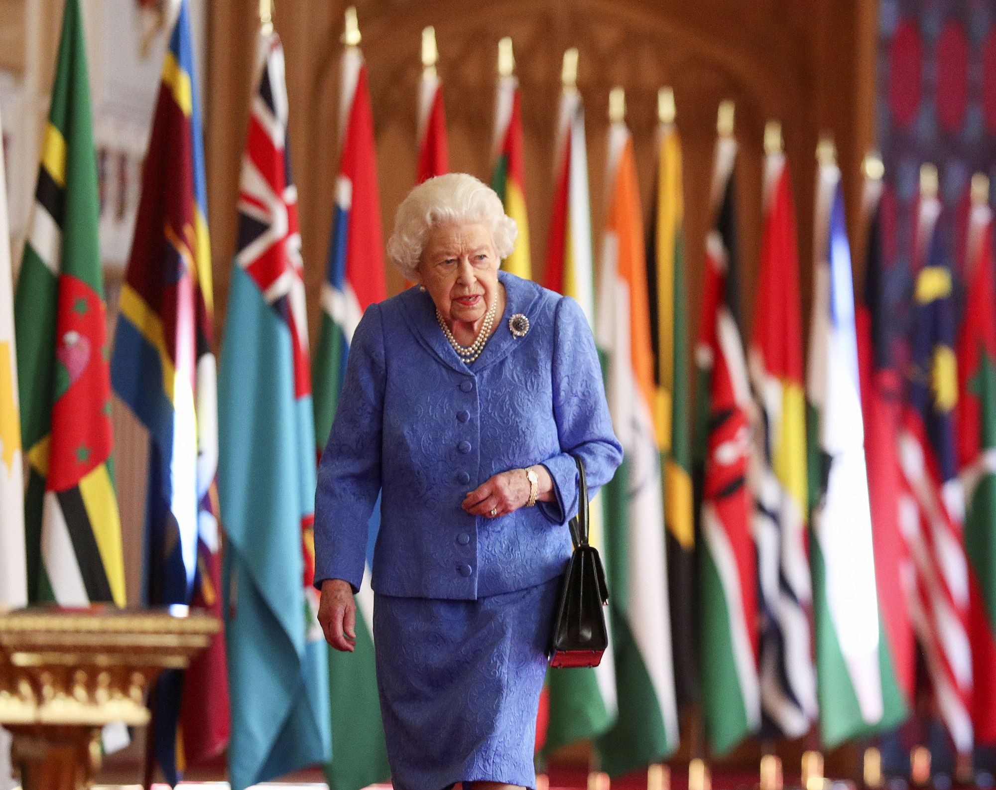 Queen Elizabeth walks past the flags of the Commonwealth member countries as part of Commonwealth Day at St. George’s Hall in Windsor Castle, on March 6. Photo: PA Wire/DPA