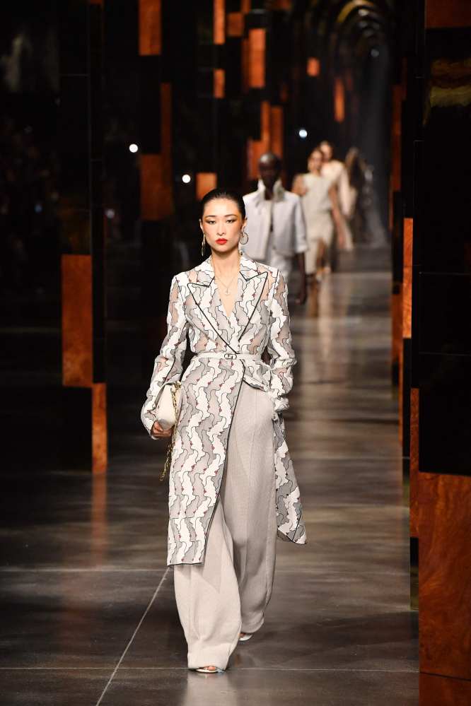 Models strutted down the runway in white monochrome tailored suits with exaggerated lapels and wide leg trousers. Photo: AFP