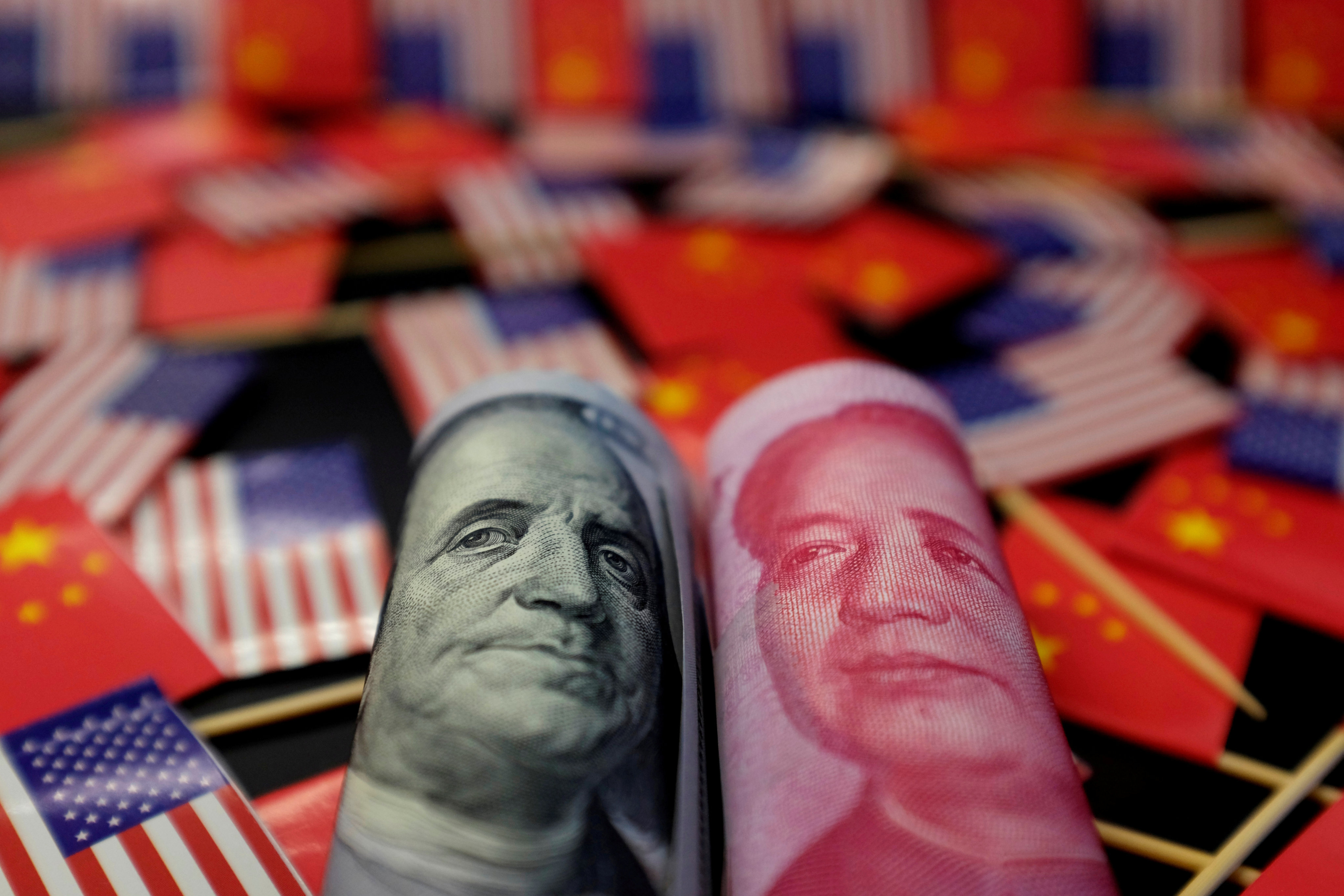 A 100 US dollar bill and a 100 yuan banknote. Photo: Reuters