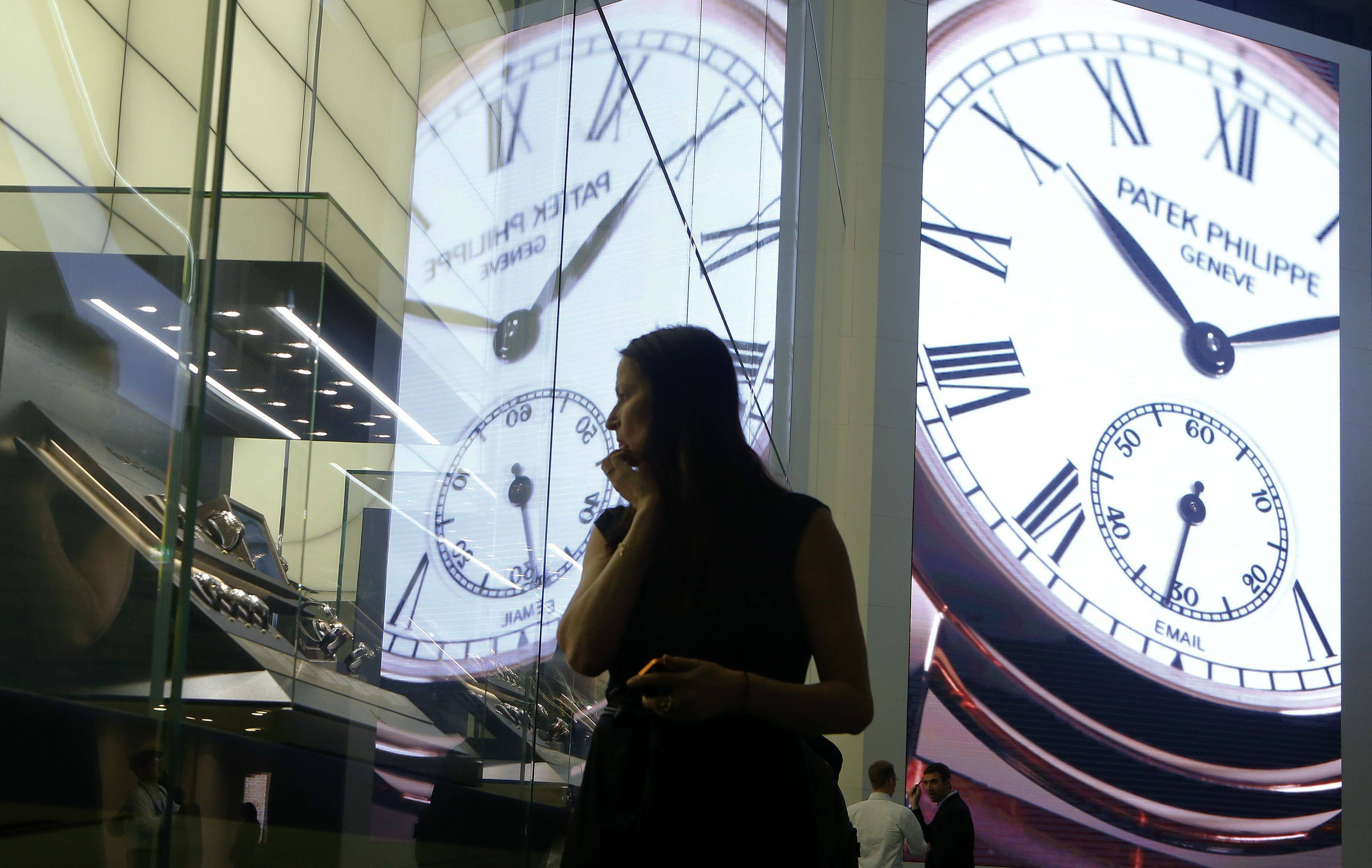 A woman looks at watches displayed at the exhibition stand of Swiss watch manufacturer Patek Philippe at Baselworld fair in Basel April 26, 2014. The world’s leading watch and jewellery show Baselworld is to be held in Basel from March 27 to April 3, 2014.   REUTERS/Arnd Wiegmann (SWITZERLAND - Tags: BUSINESS SOCIETY)