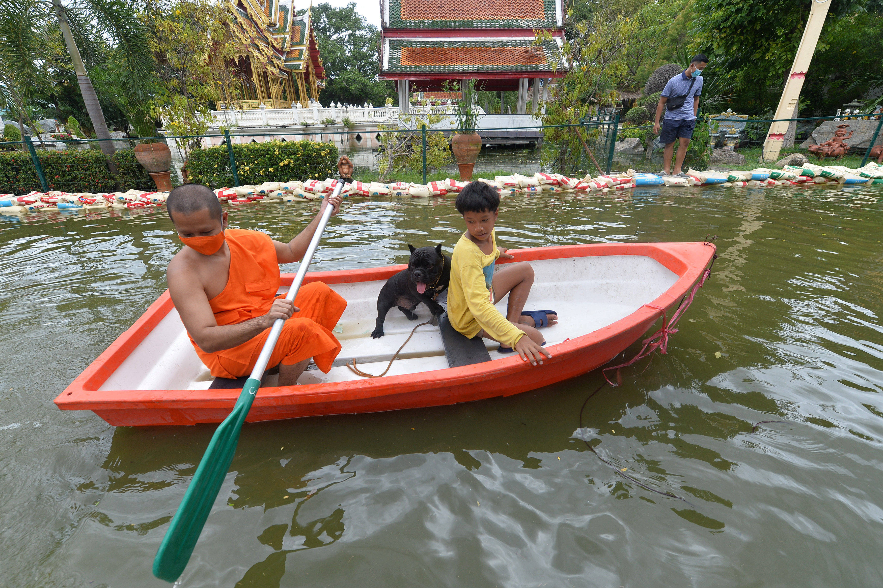 A monk rows a boat along a flooded road on the outskirts of Bangkok, Thailand, on September 3. Extreme weather events, once the stuff of movies, have been playing out across the planet this year. Photo: Xinhua