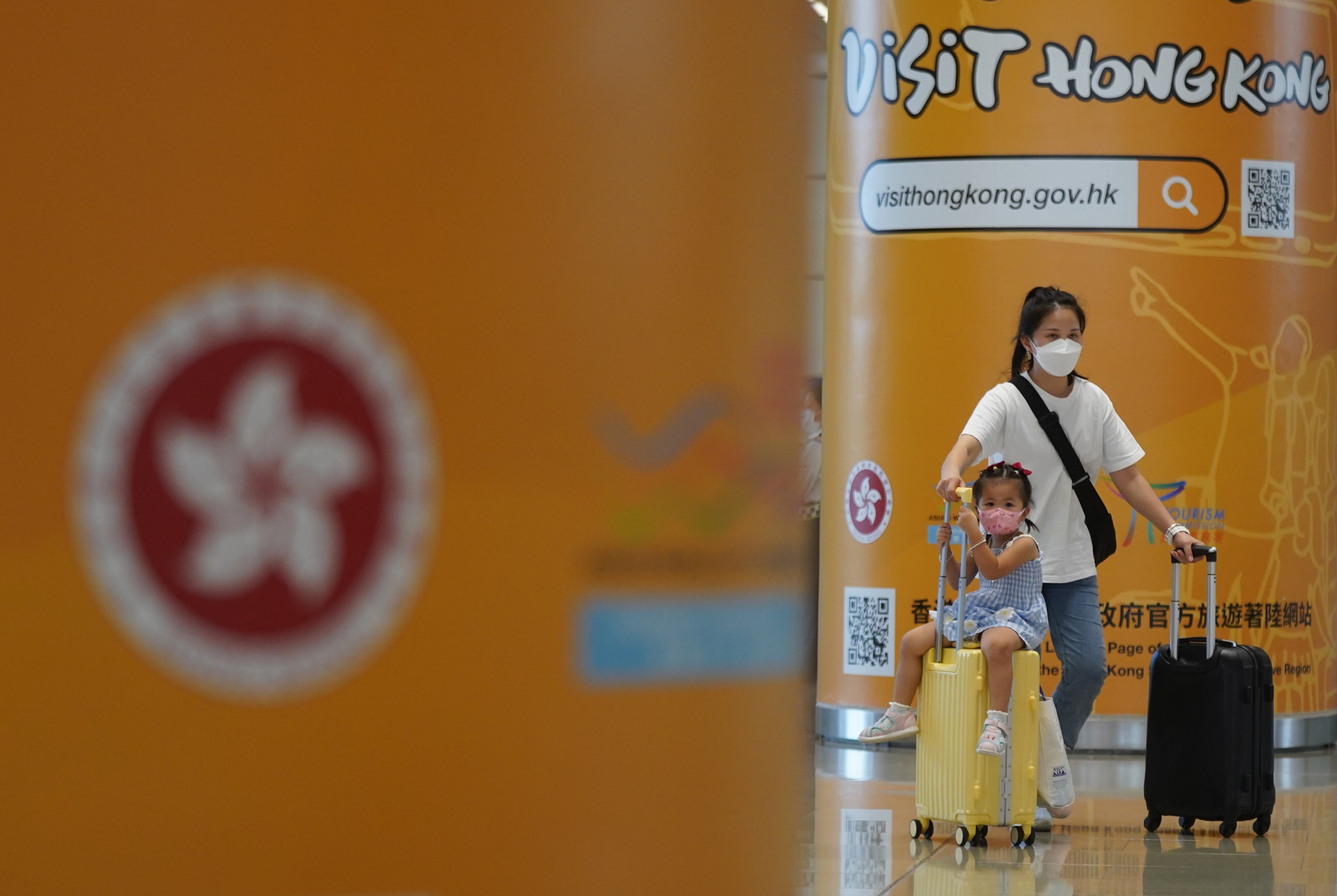 A woman and child walk past a Visit Hong Kong tourism poster at the port at the Hong Kong-Zhuhai-Macao Bridge on September 15. Photo: Sam Tsang