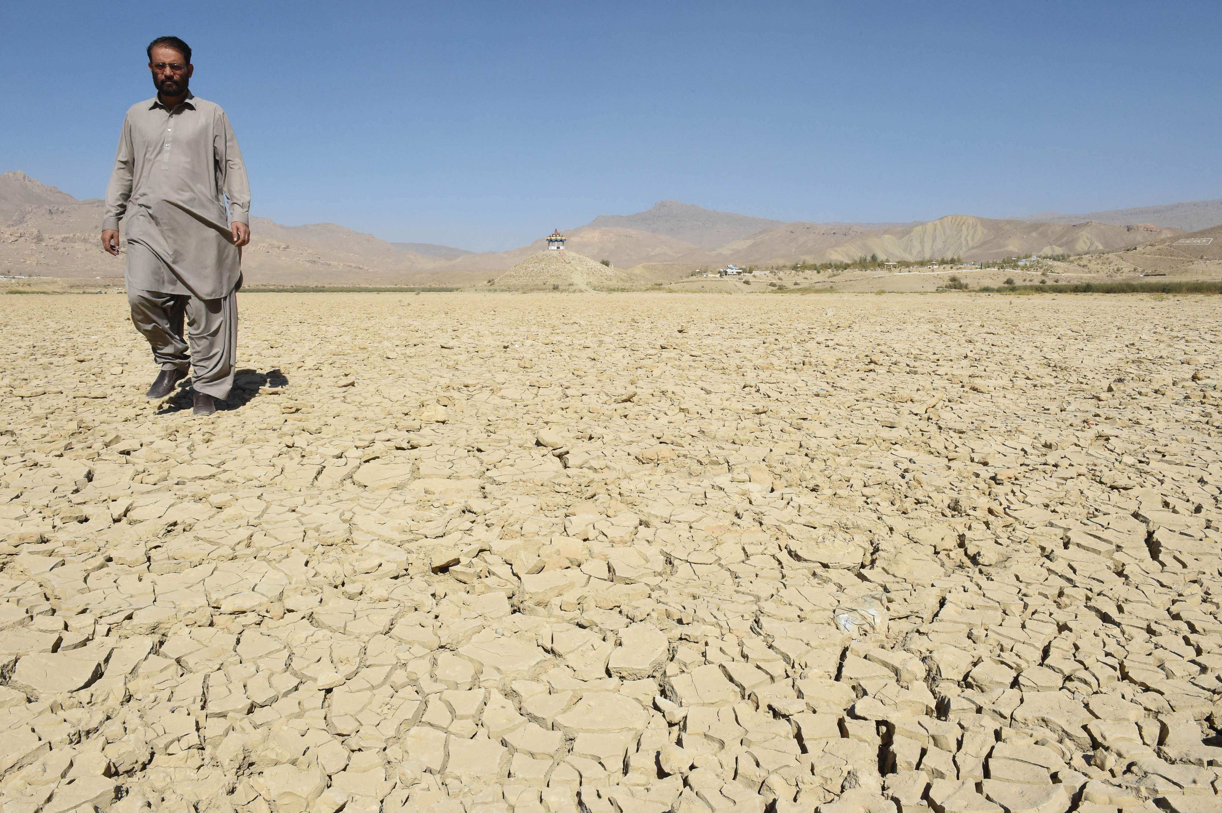 A Pakistani villager walks on the dry Hanna lake in Urak Valley, some 15km from Quetta, on October 6, 2018. Some half a million people have been displaced because of severe droughts caused by a lack of rain. Photo: AFP