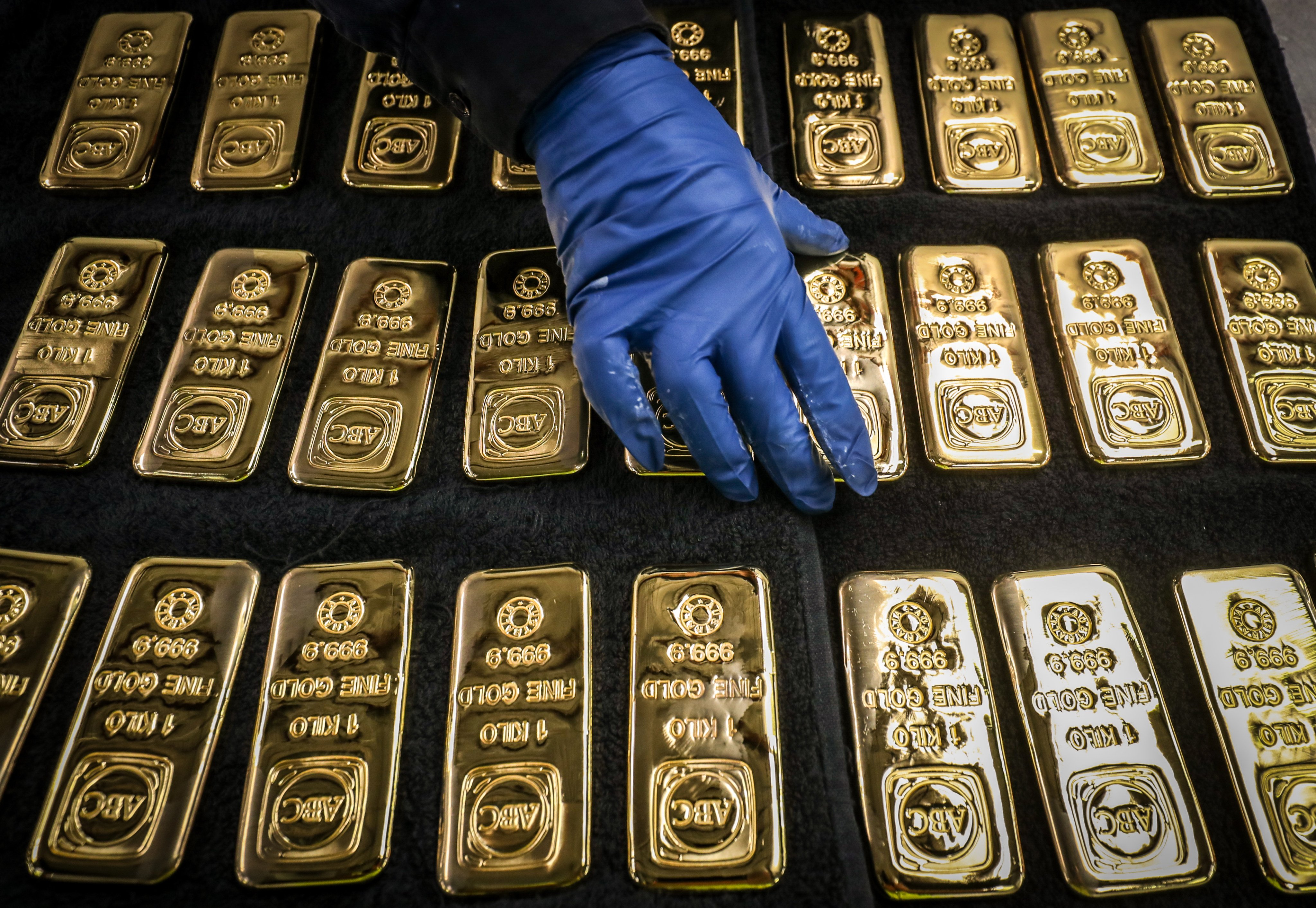 A worker handles 1kg gold bars in Sydney. Photo: Bloomberg