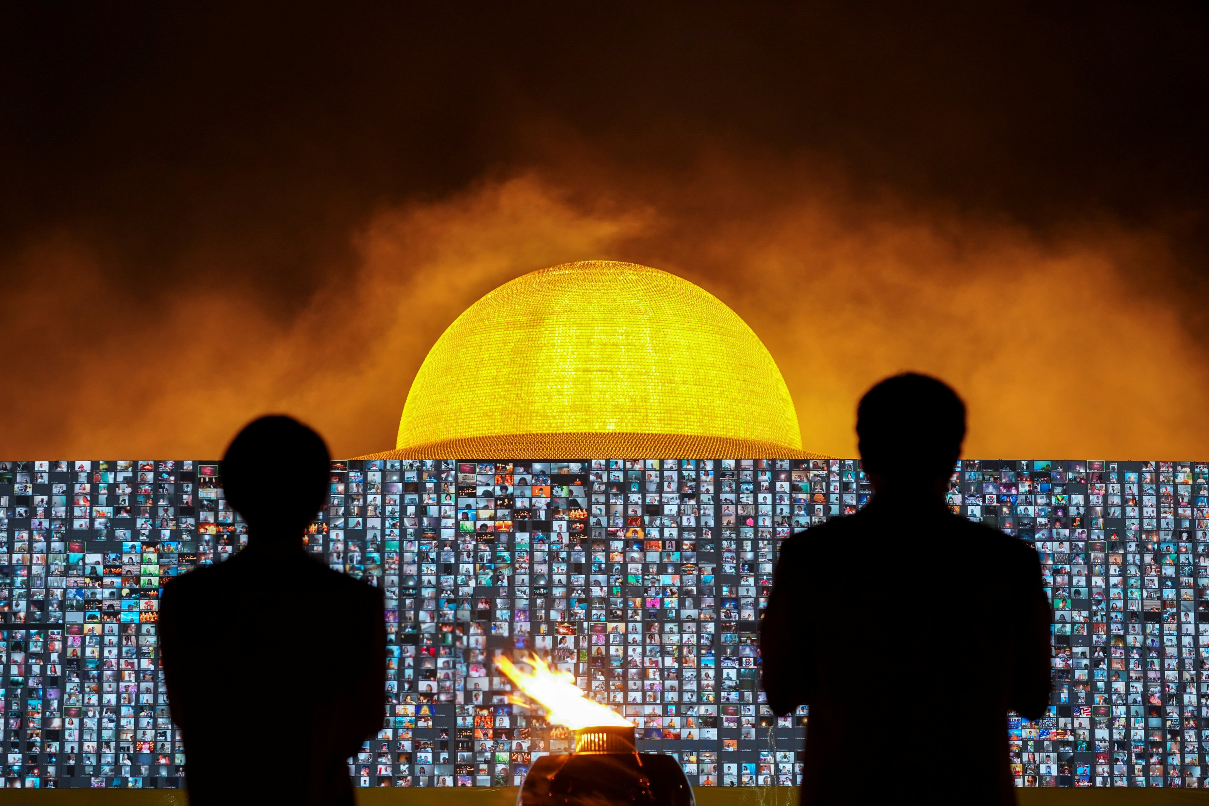 People pray as screens show devotees gathering via Zoom during a ceremony to commemorate Makha Bucha Day at the Wat Phra Dhammakaya temple, in Pathum Thani province, Thailand, on February 26. Photo: Reuters