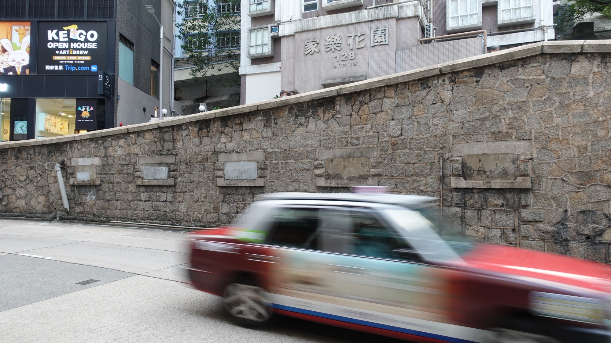A stone wall containing concrete-filled windows that separates Queen’s Road West from a slope known as Bird Bridge. Photo: Nikolas Ettel