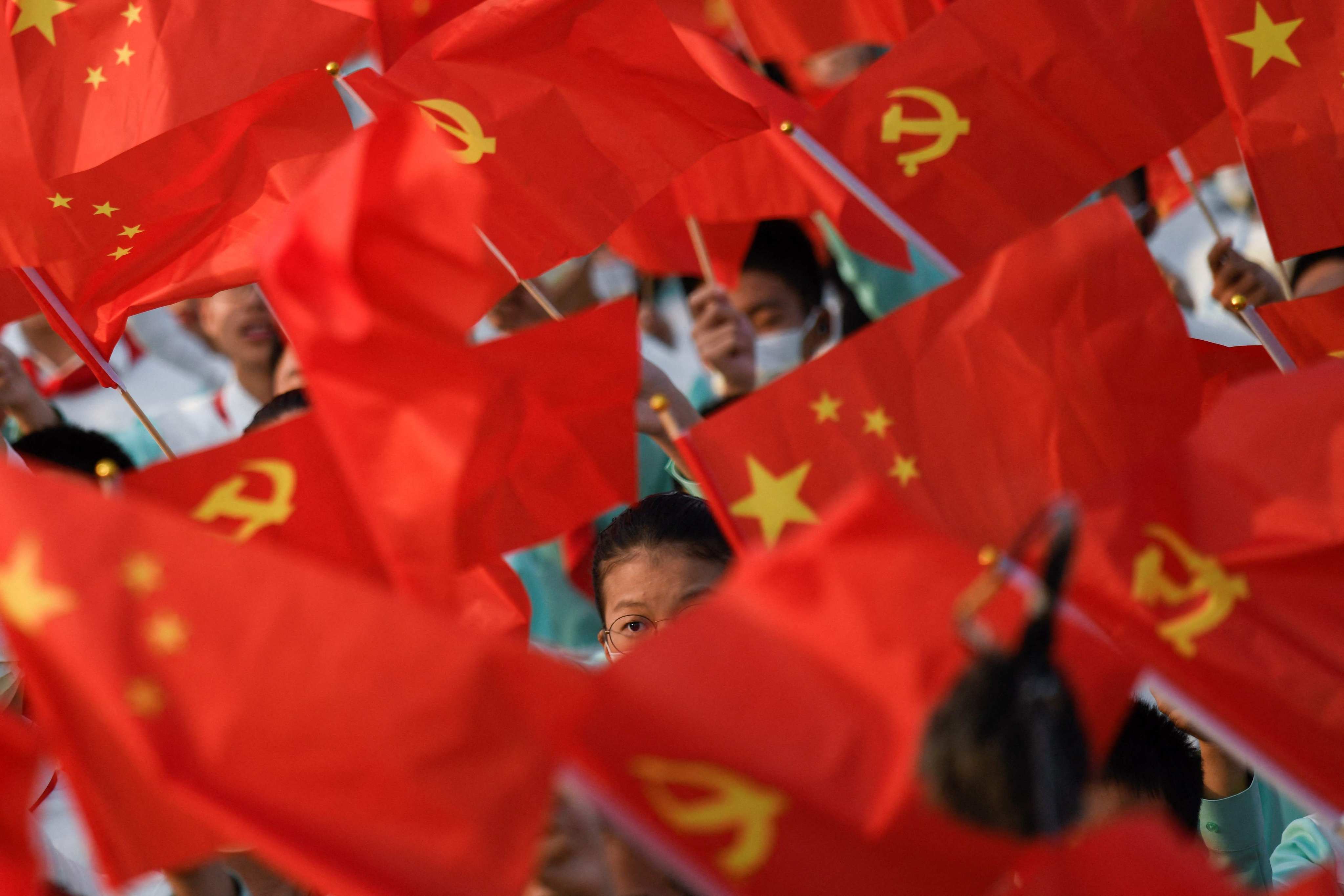 Students wave the flags of China and the Communist Party of China before celebrations in Beijing on July 1, 2021, to mark the 100th anniversary of the founding of the Communist Party of China. Photo: AFP