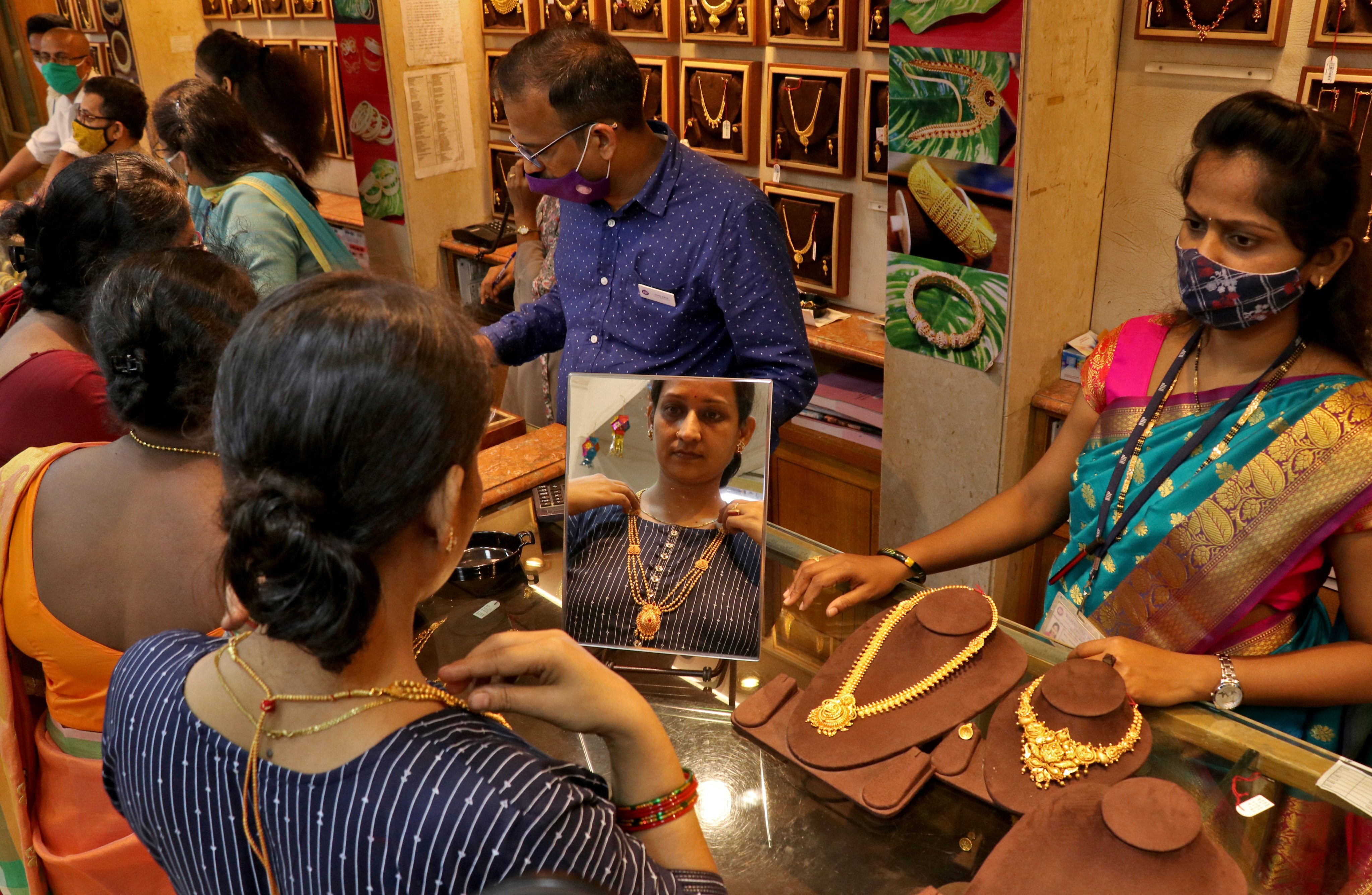 A woman tries on a gold necklace at a jewellery showroom during the Dhanteras festival in Mumbai on November 2. Gold is traditionally considered a store of value in the face of economic calamity. Photo: Reuters