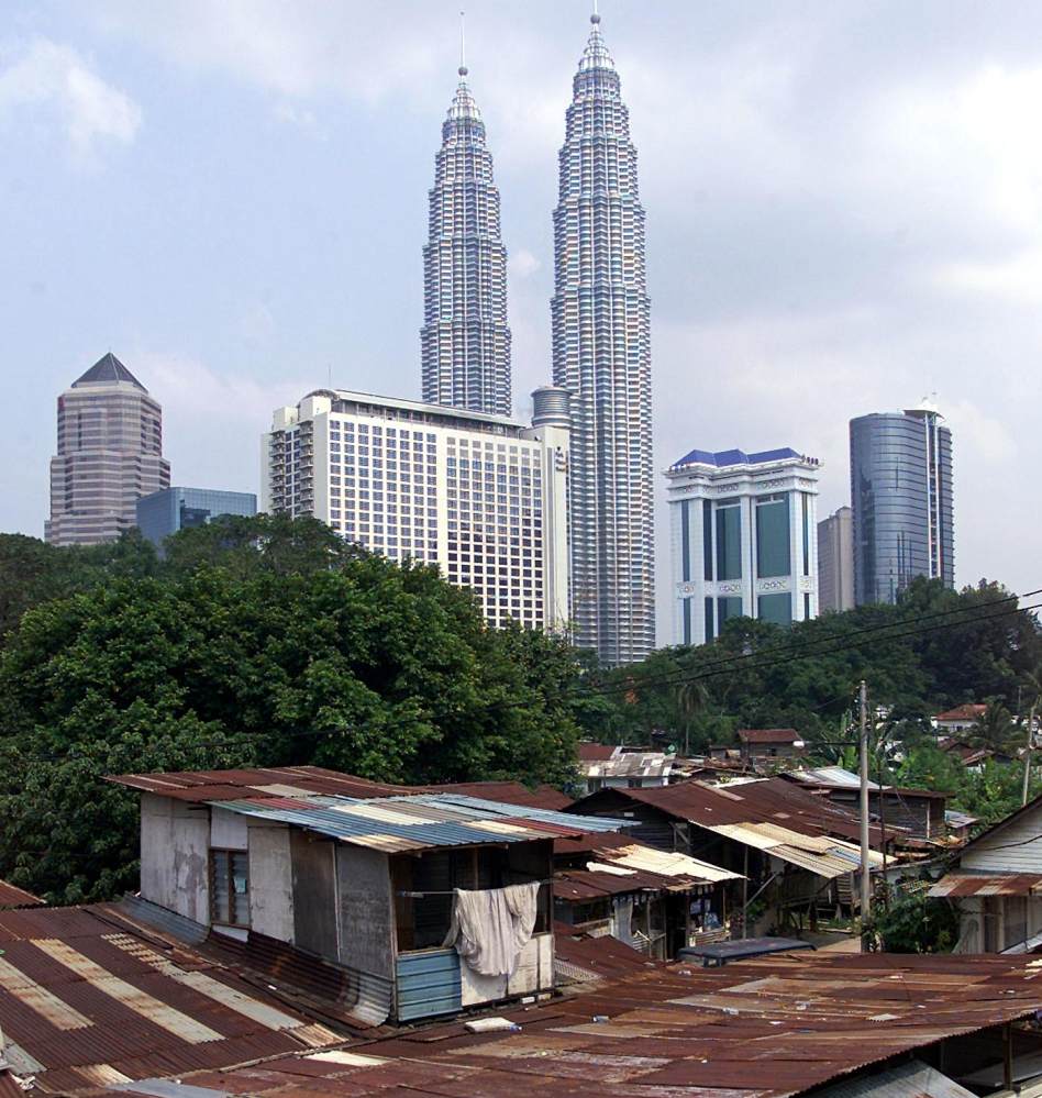 Shacks are seen against the backdrop of the Petronas Towers in Kuala Lumpur. Photo: AFP