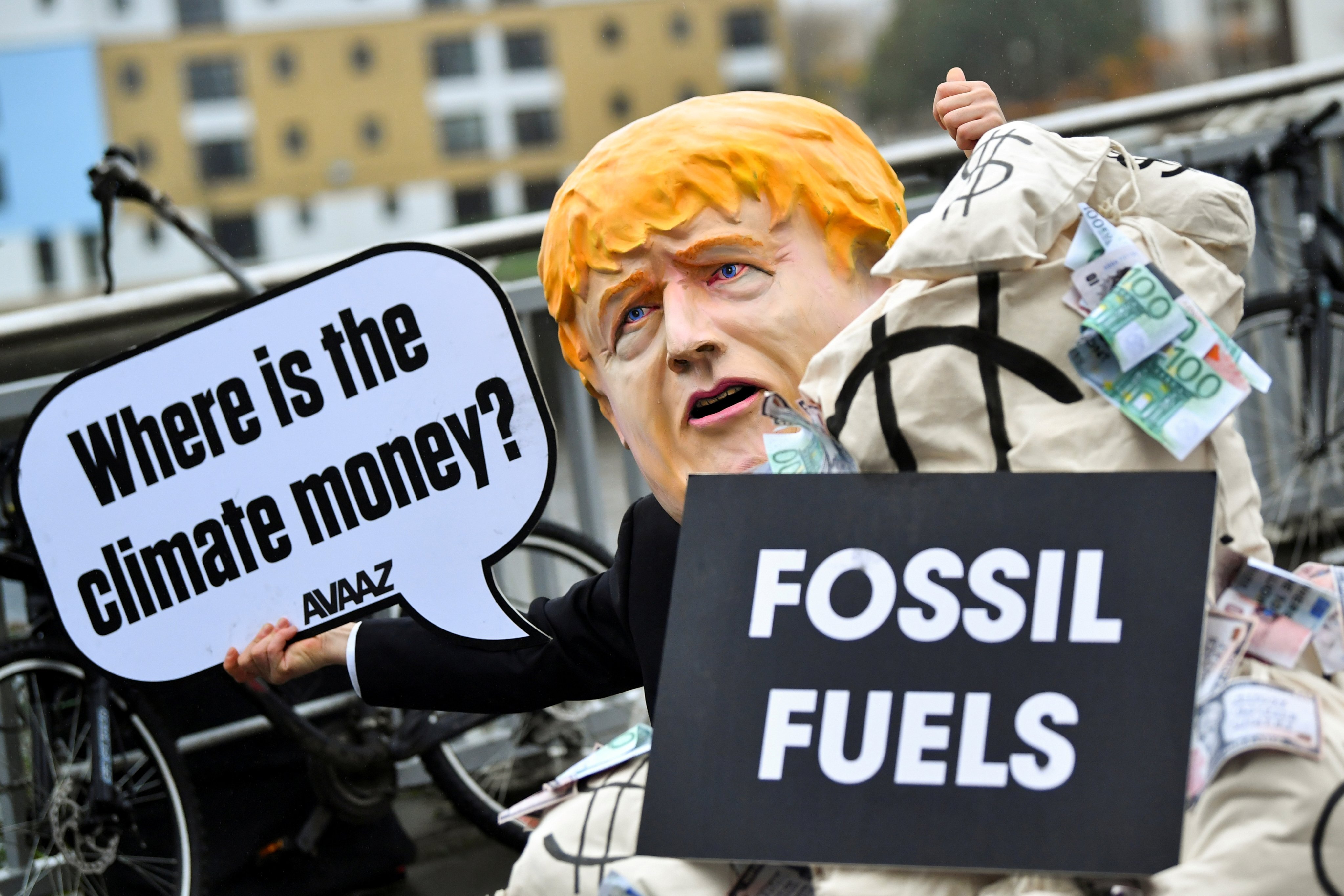 A person wearing a mask depicting Britain’s Prime Minister Boris Johnson protests during COP26 in Glasgow, Scotland, on November 12. An effective carbon trading system is a necessary tool in the transition to a net-zero economy. Photo: Reuters