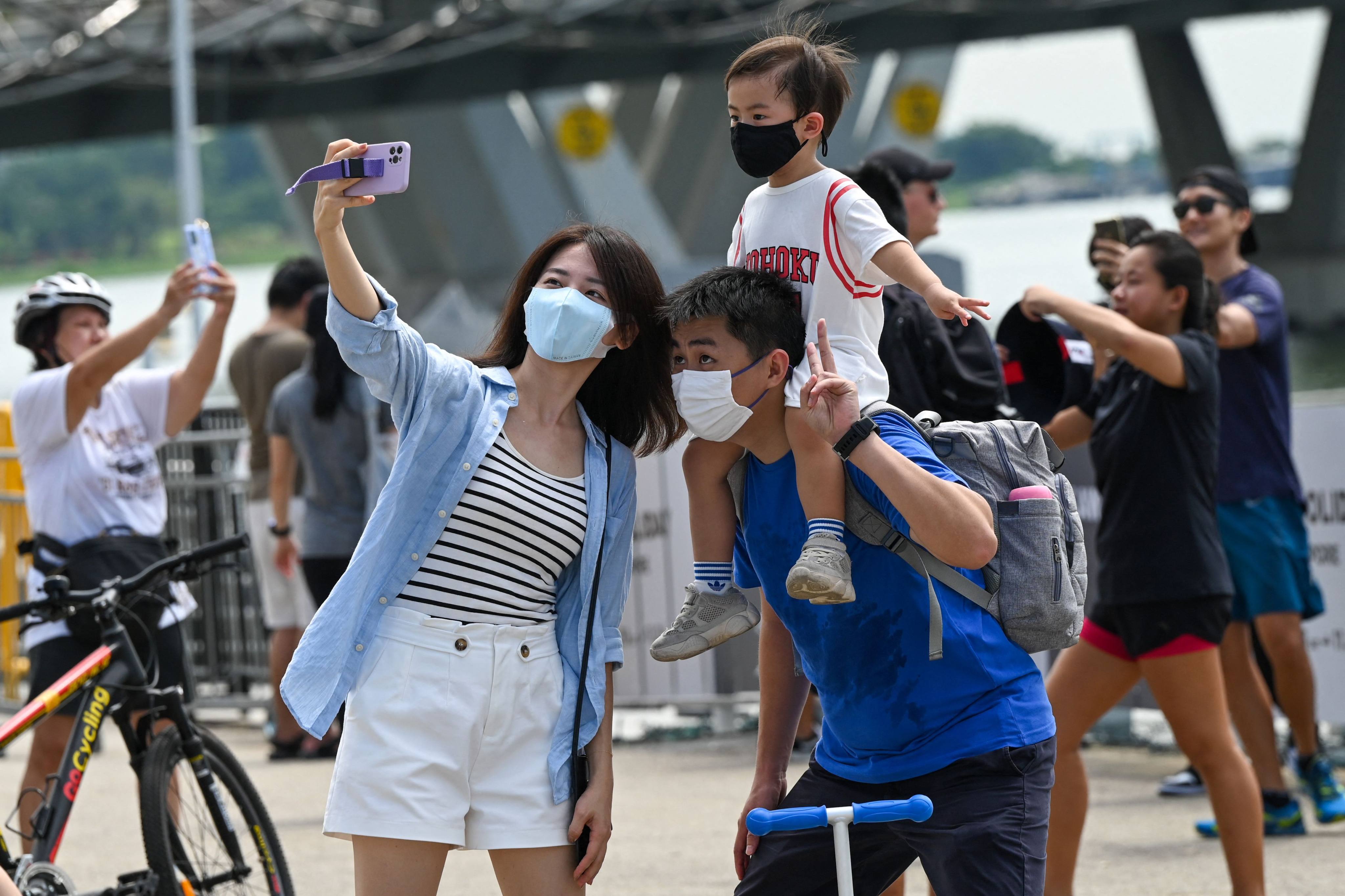 People gather to take selfies next to The Float at Marina Bay in Singapore on November 14, 2021. Photo: AFP