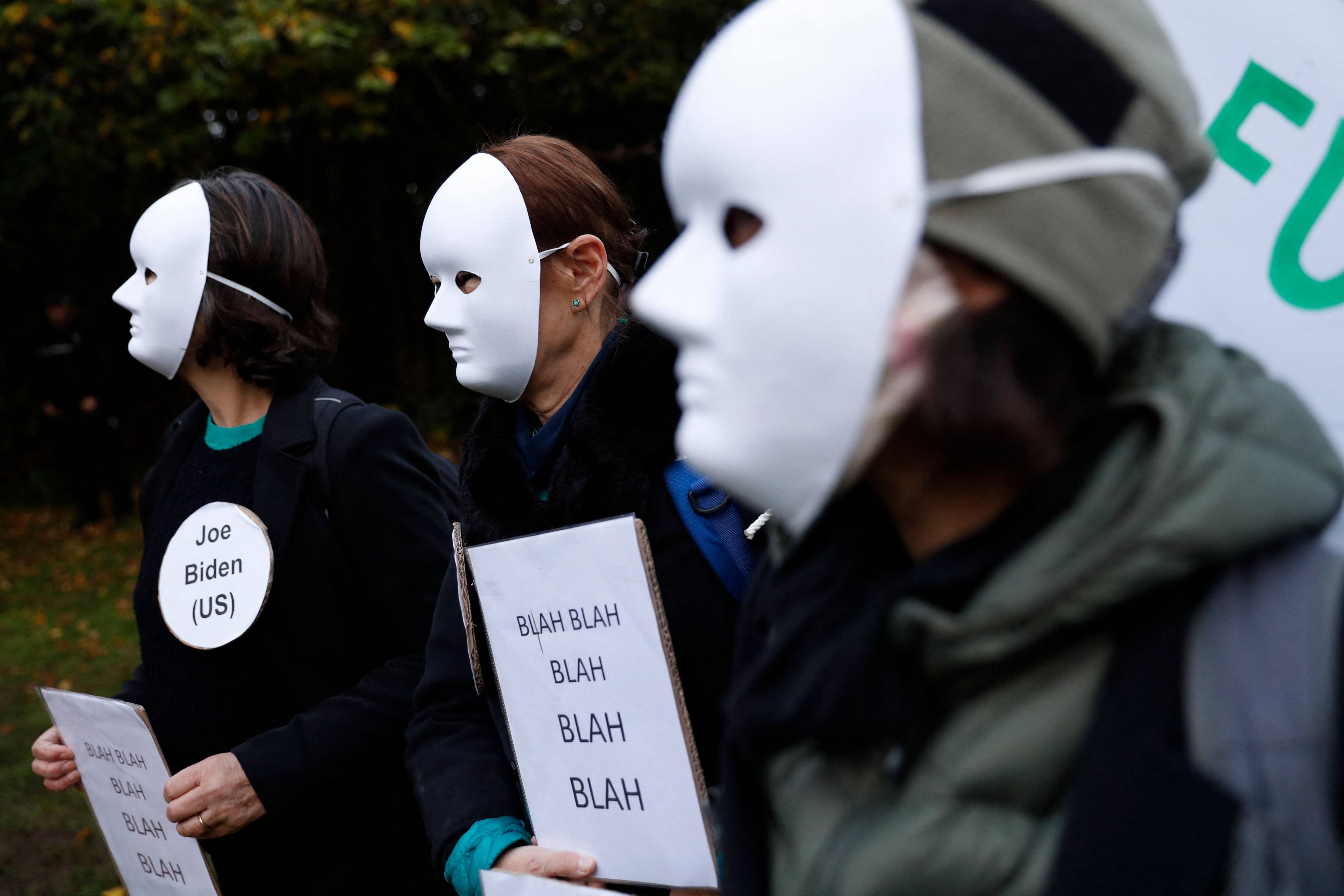 Climate activists hold placards mocking statements by world leaders during a protest at Festival Park in Glasgow on November 1. Photo: AFP