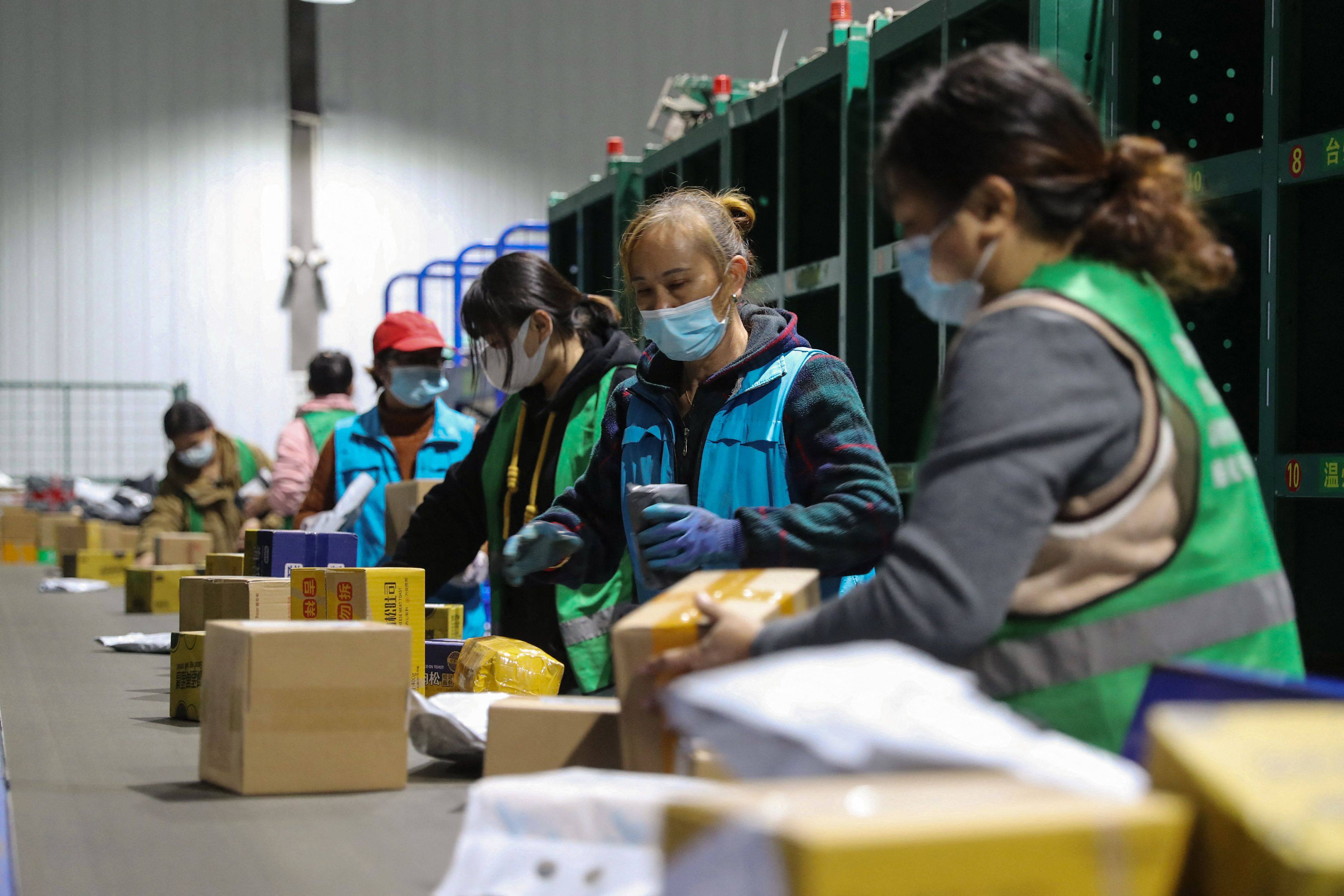 Workers sort packages at a logistics firm in Hunan province, China. Photo: AFP