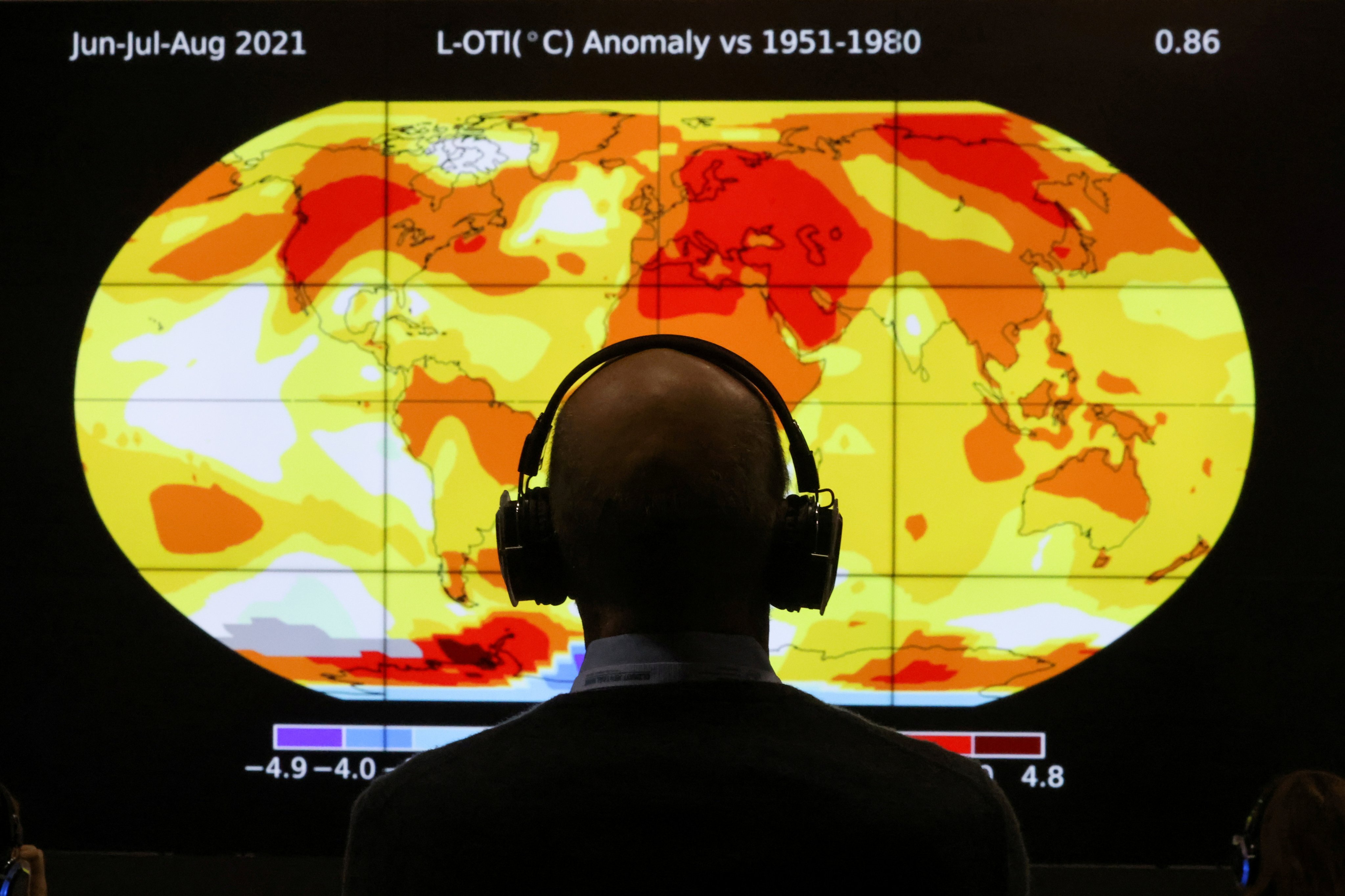 A delegate looks at a screen showing a world map during the COP26 conference in Glasgow, Scotland, on November 8. Photo: Reuters 