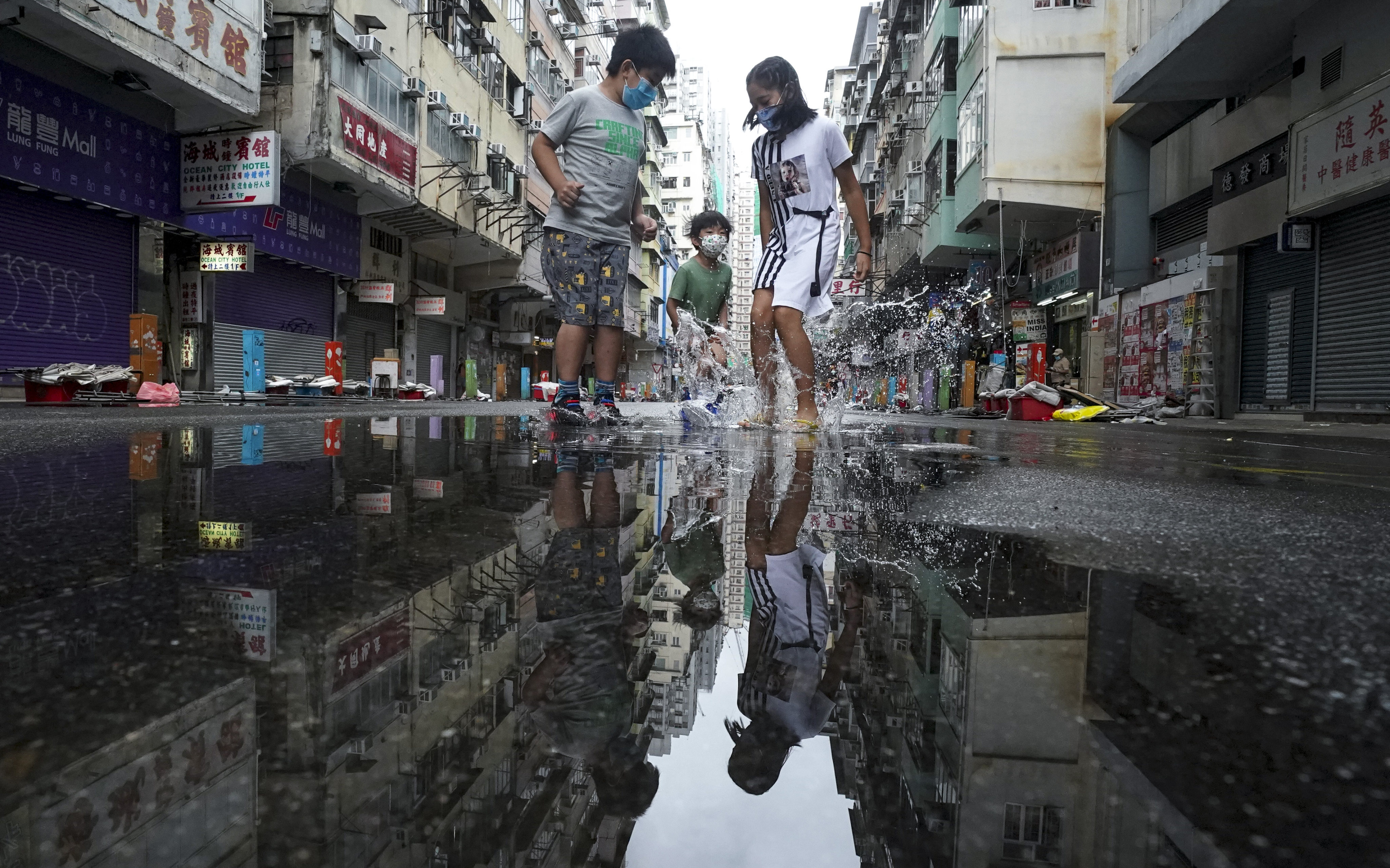 Children splash in puddles on Tung Choi Street on October 13. In rich and peaceful Hong Kong, every child should be happily going to school, getting a good education and playing with their peers. Photo: Felix Wong