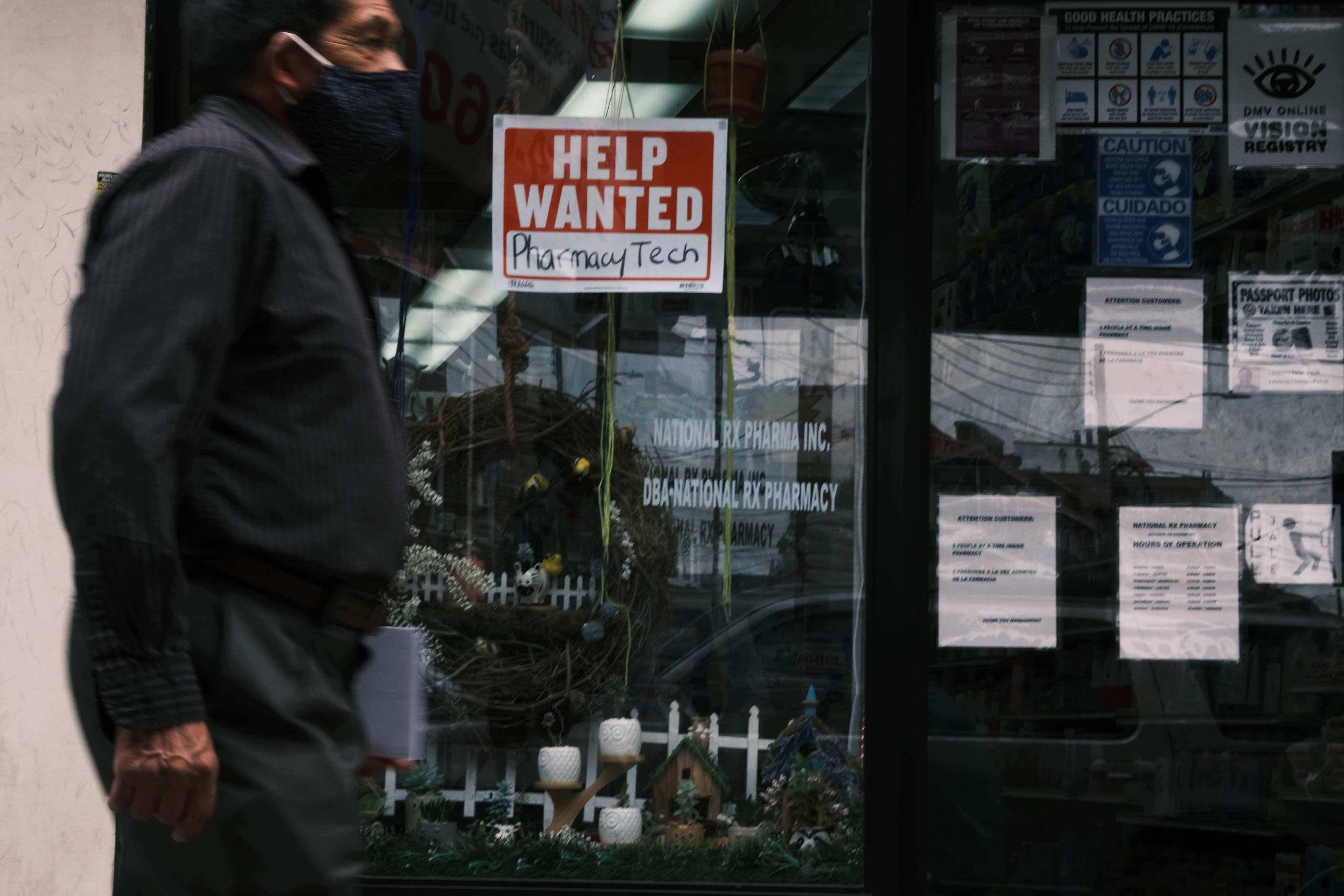 A man walks by a “Help Wanted” sign in Queens, New York, on June 4. The US economy continues to add jobs every month but millions of Americans remain unemployed. Photo: AFP
