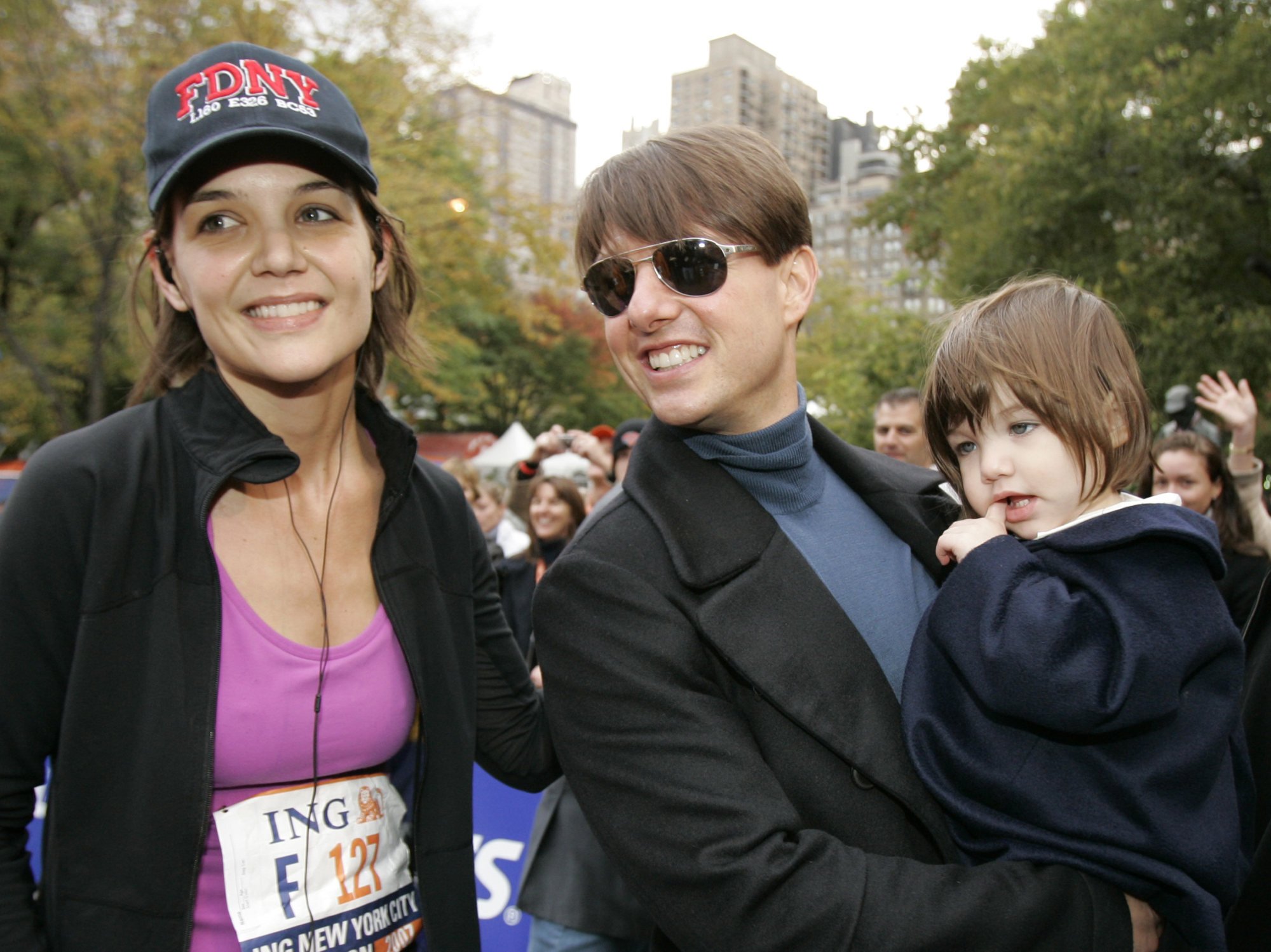 Actress Katie Holmes with Tom Cruise as he holds their daughter Suri after Holmes finished the New York City Marathon in 2007. Photo: AP Photo