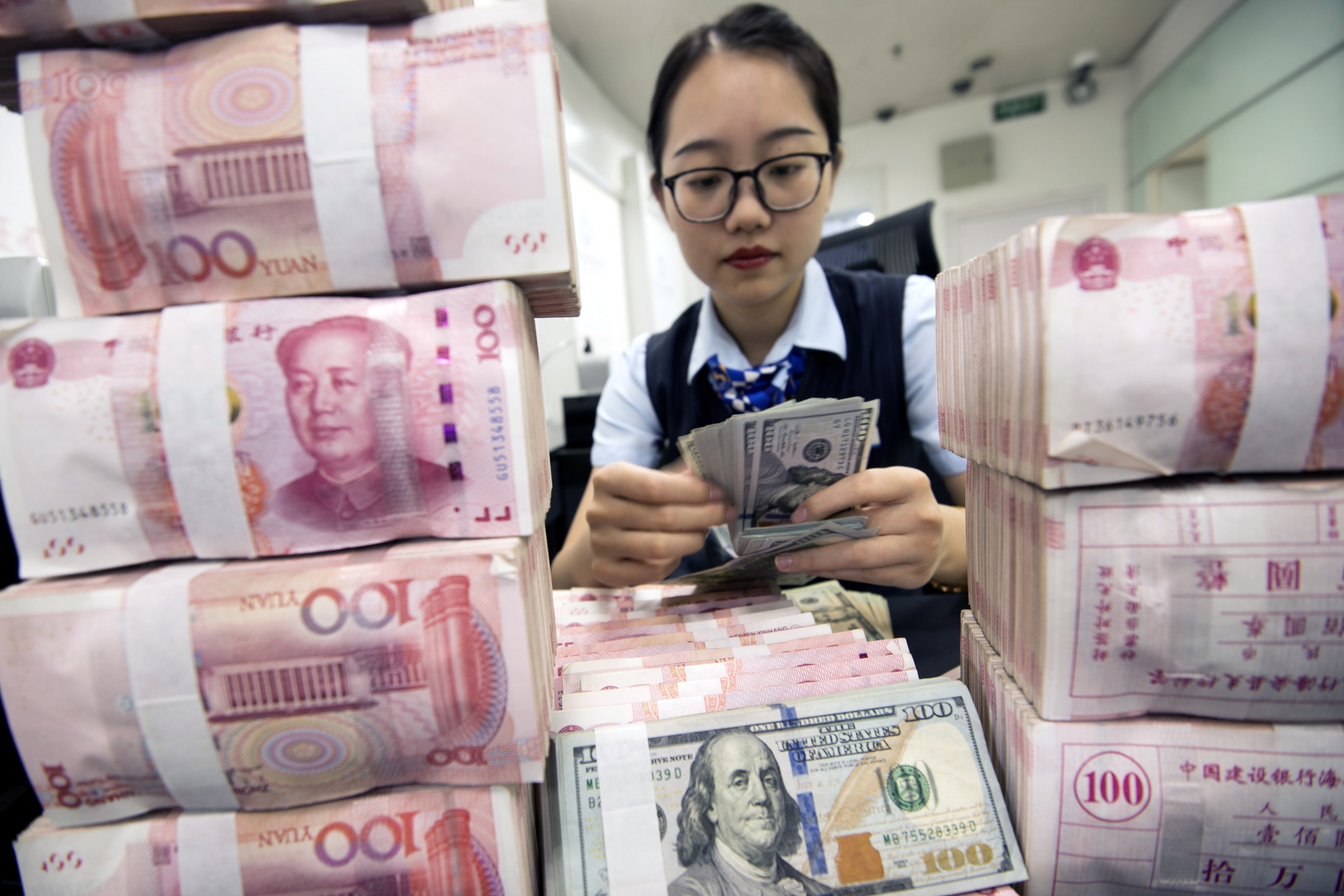 A clerk counts banknotes at a bank outlet in Hai’an, Jiangsu province, China. Photo: EPA-EFE