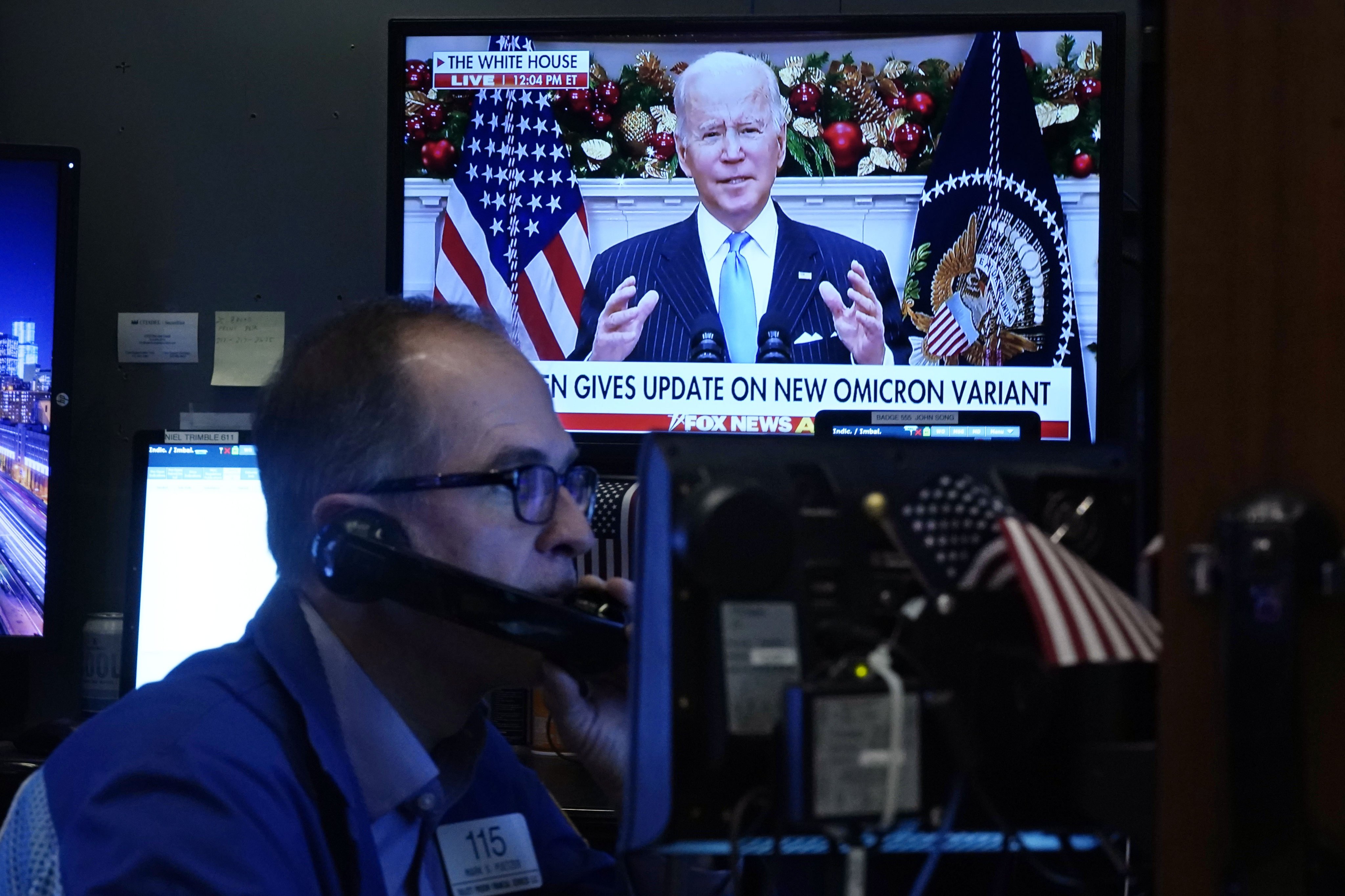 A trader works at the New York stock exchange on November 29 as US President Joe Biden appears on a screen urging Americans to get vaccinated as he sought to quell concerns over the Omicron variant. Photo: AP 