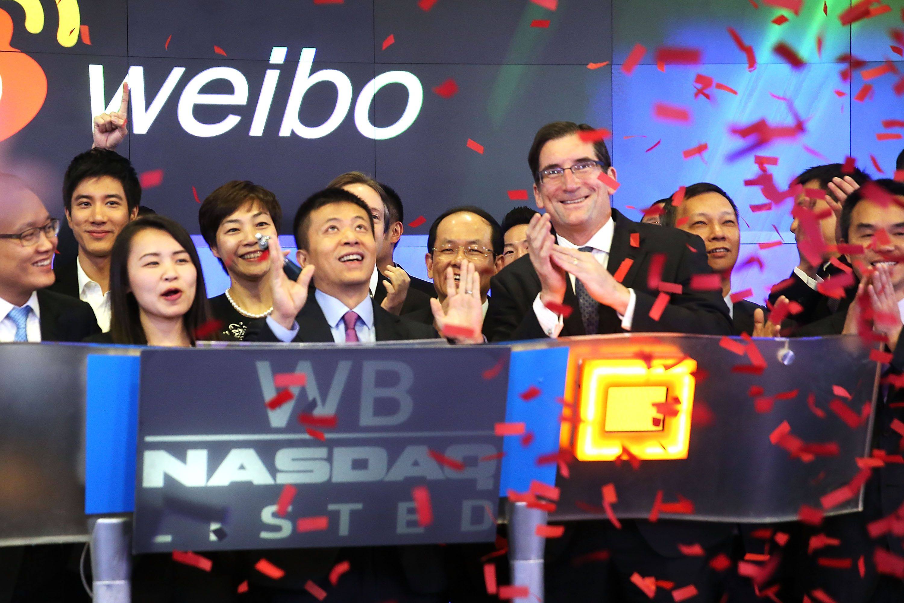 Weibo CEO Charles Chao (centre) celebrates moments after Weibo began trading on the Nasdaq stock exchange on April 17, 2014 in New York. The company is seeking a secondary listing in Hong Kong this month. Photo: AFP
