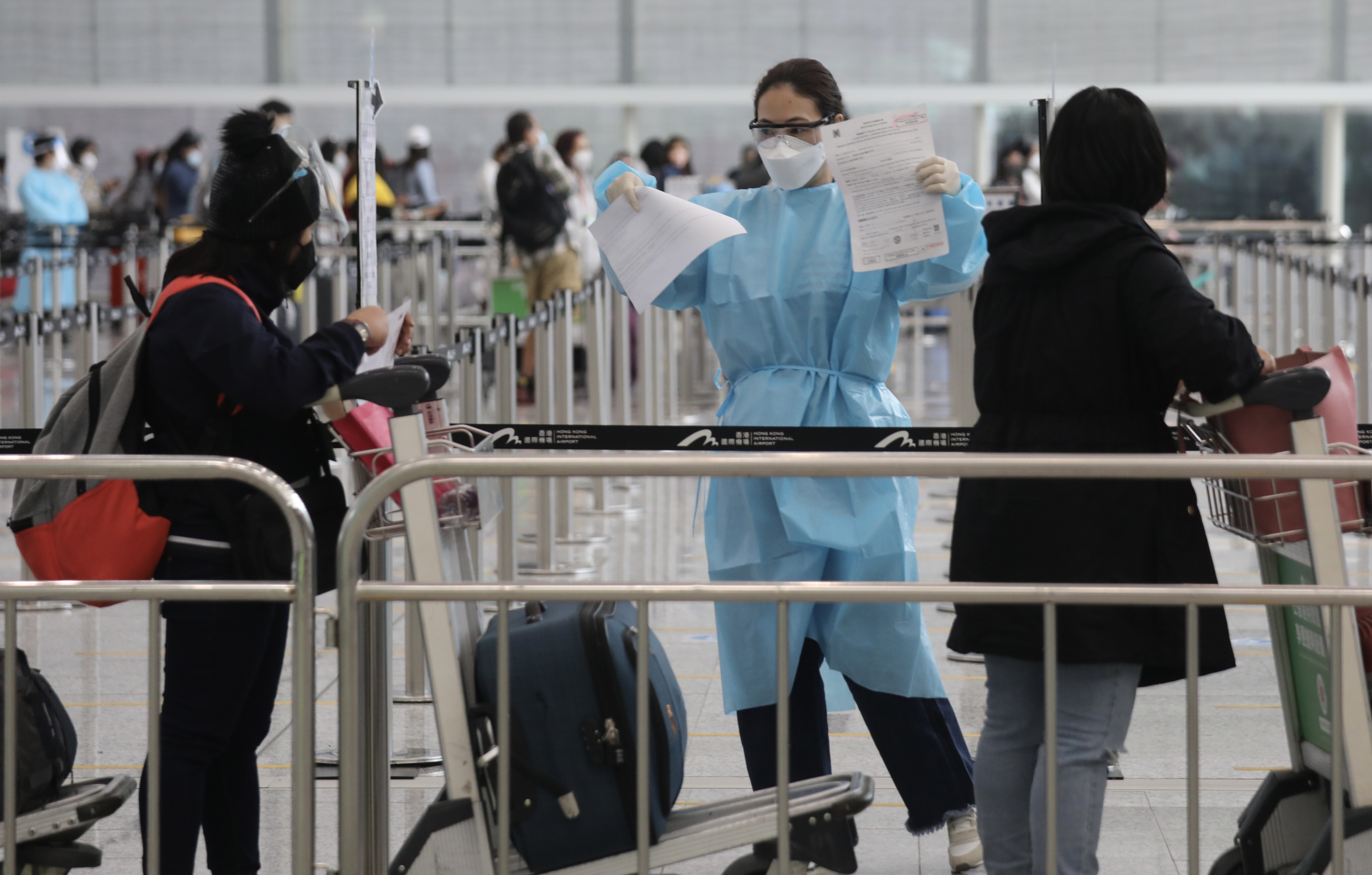 A staff member checks arriving passengers’ health documents at Hong Kong International Airport. Photo: Xiaomei Chen