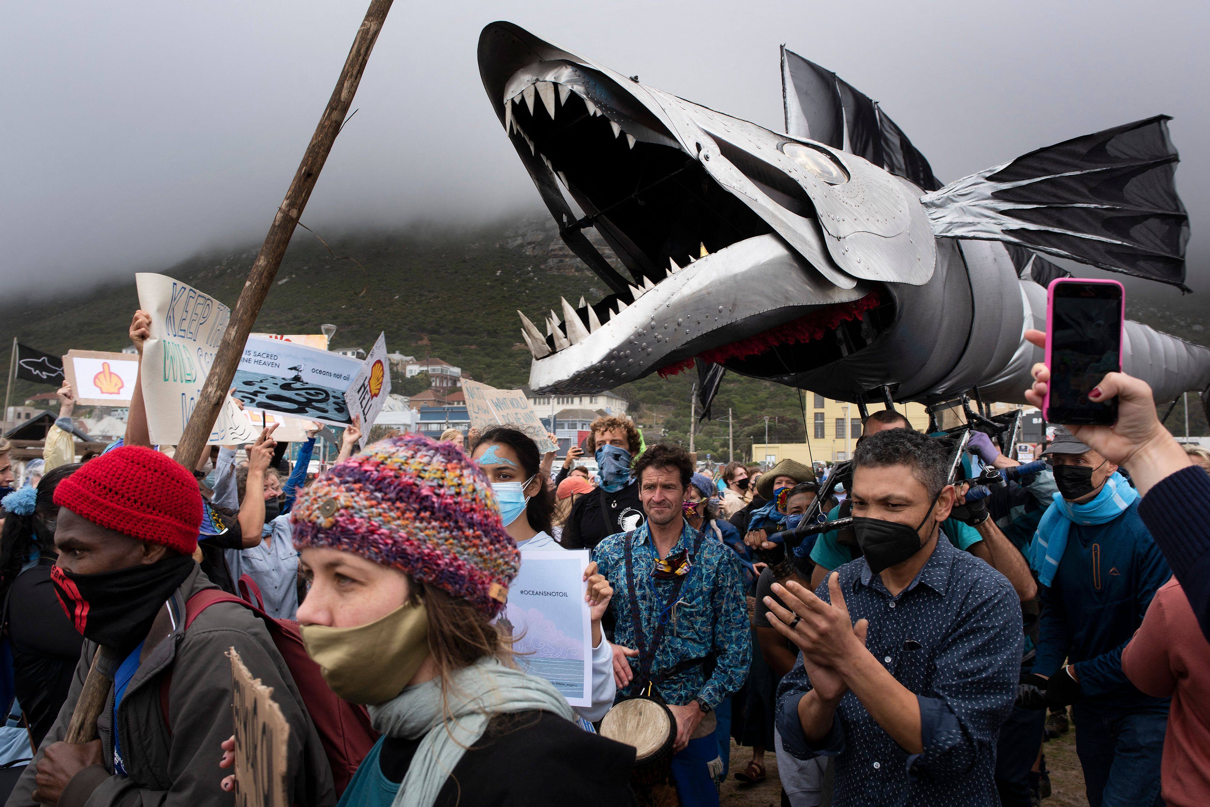 A giant puppet of a snoek, a type of mackerel, is displayed as hundreds of people take part in a protest against Dutch oil company Shell at Muizenberg Beach, Cape Town, South Africa on Sunday. Photo: AFP