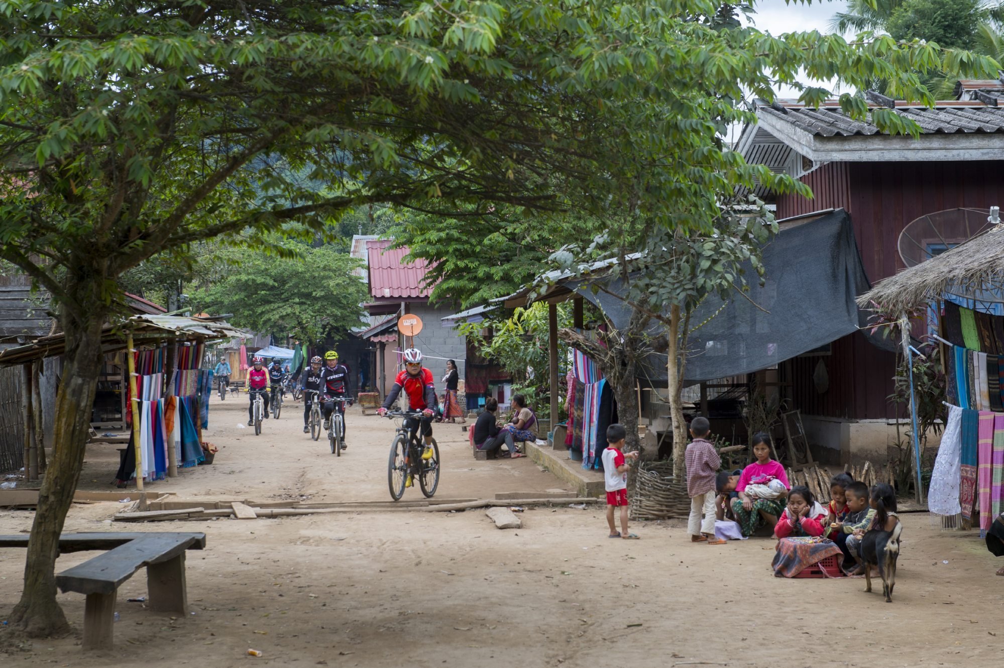 Cyclists ride through a cultural heritage village in Central Laos. The Laotian economy remains fragile, with Chinese investment so far only adding to its debt burden. Photo: Avalon/Universal Images Group via Getty Images