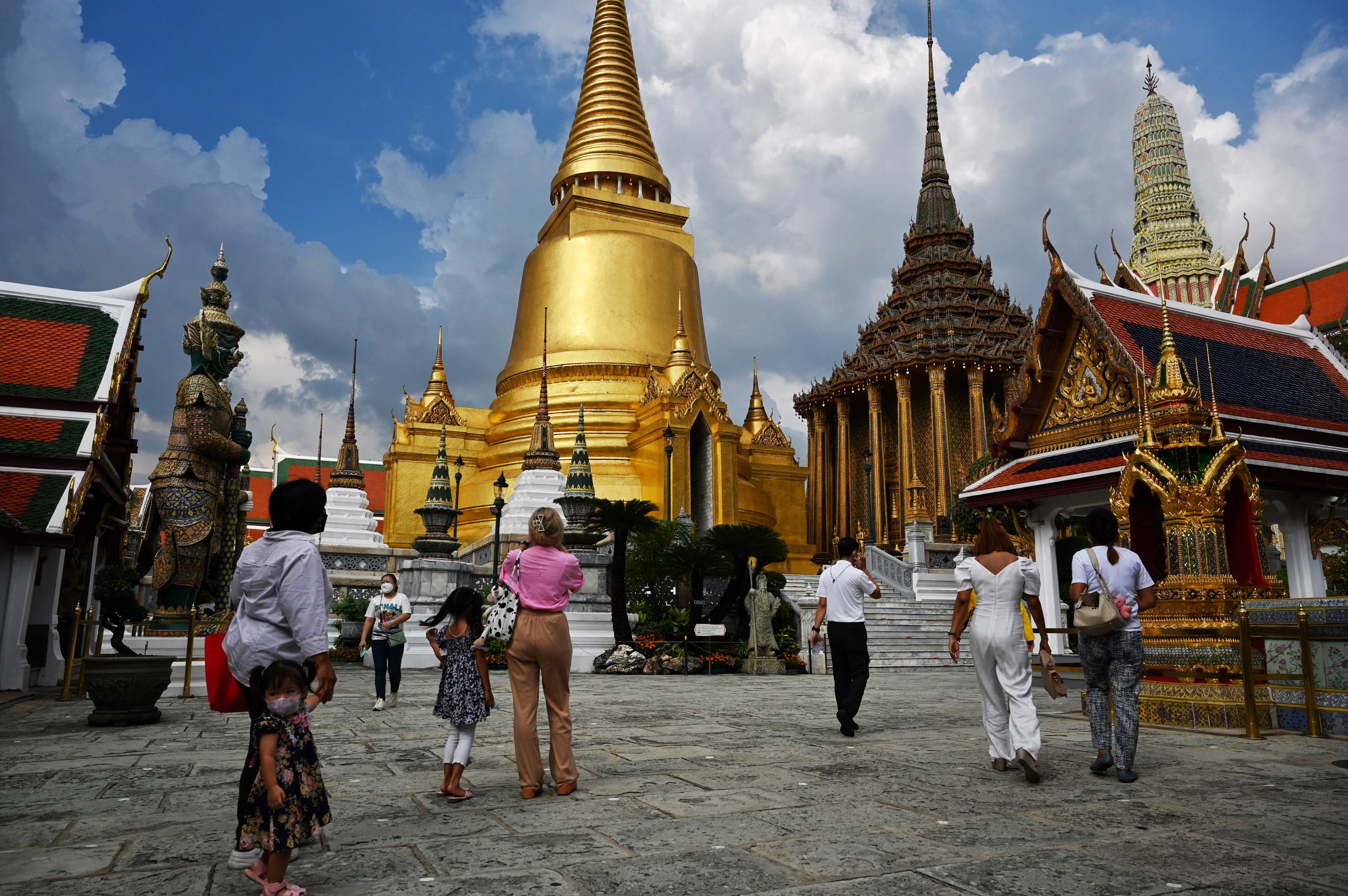 Local visitors enter the Grand Palace on the day of reopening in Bangkok on November 1, 2021, as Thailand welcomes the first groups of tourists fully vaccinated against the Covid-19 coronavirus without quarantine. (Photo by Lillian SUWANRUMPHA / AFP)