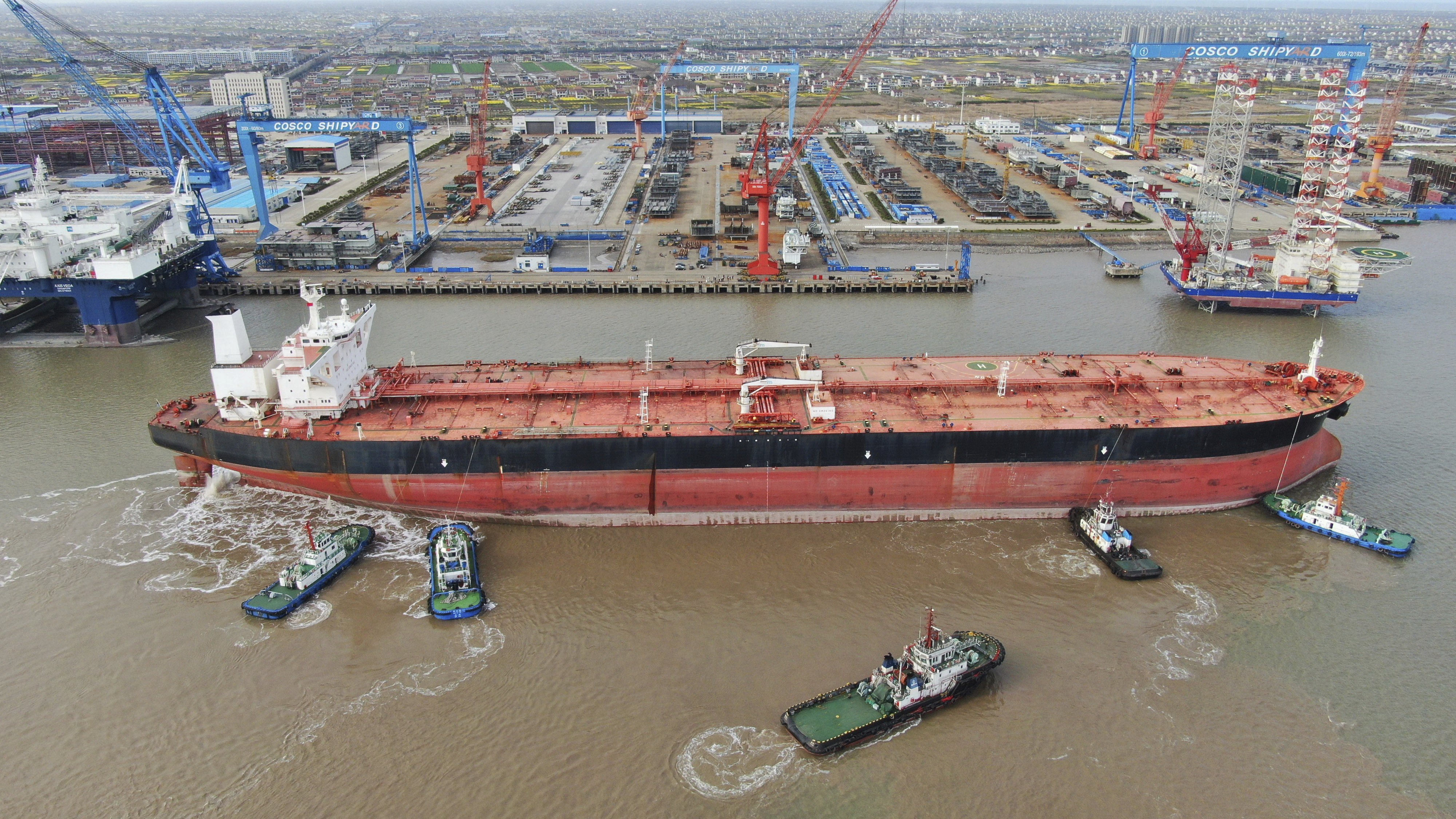 Tugboats nudging a 300,000-ton very large crude carrier (VLCC) to a shipyard on the Yangtze River for retrofitting in Qidong city in eastern China’s Jiangsu province on March 16, 2020. Photo: Chinatopix via AP.