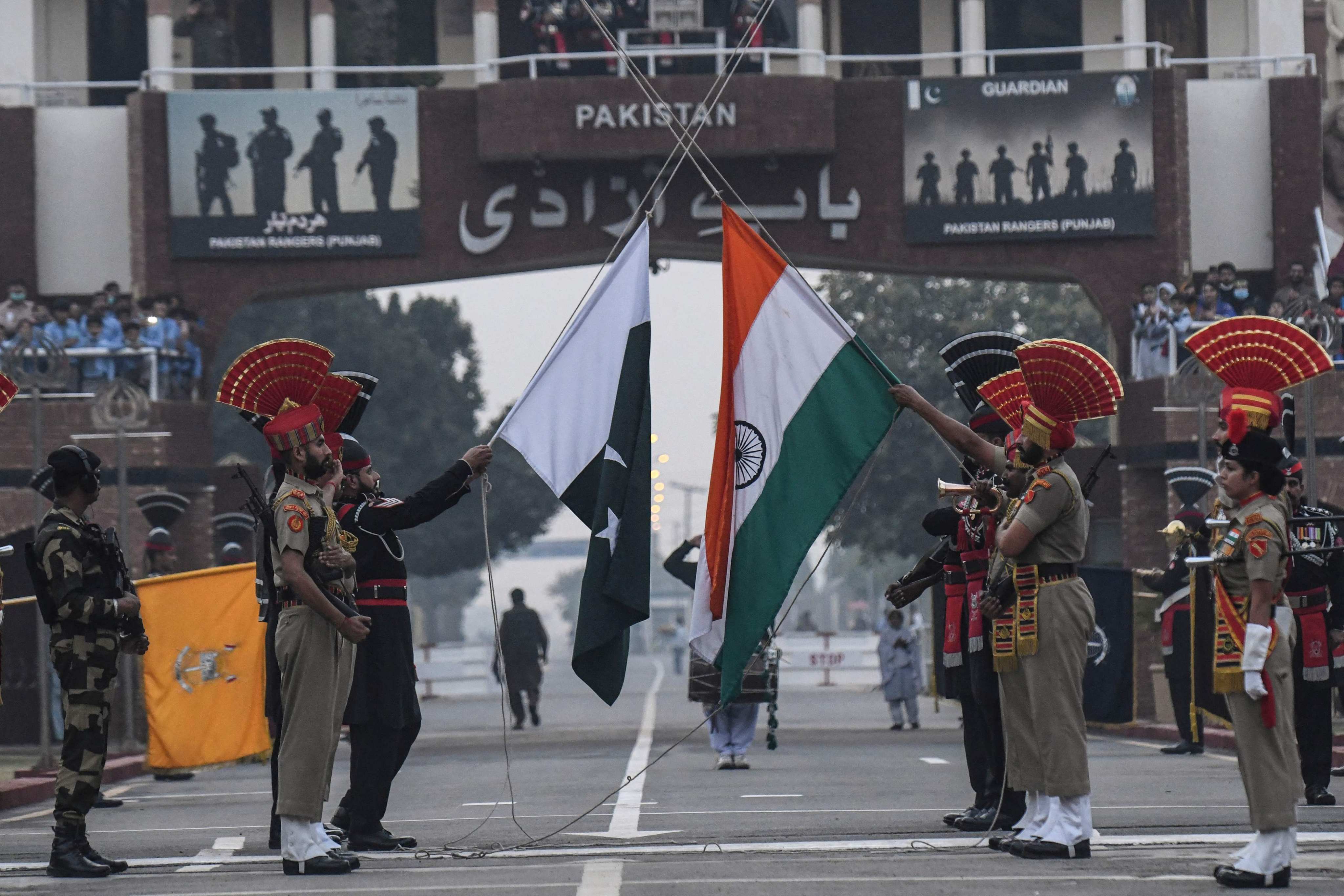 Indian and Pakistani border forces lower their respective flags at a daily ceremony held at the India-Pakistan Wagah Border Post. Photo: AFP