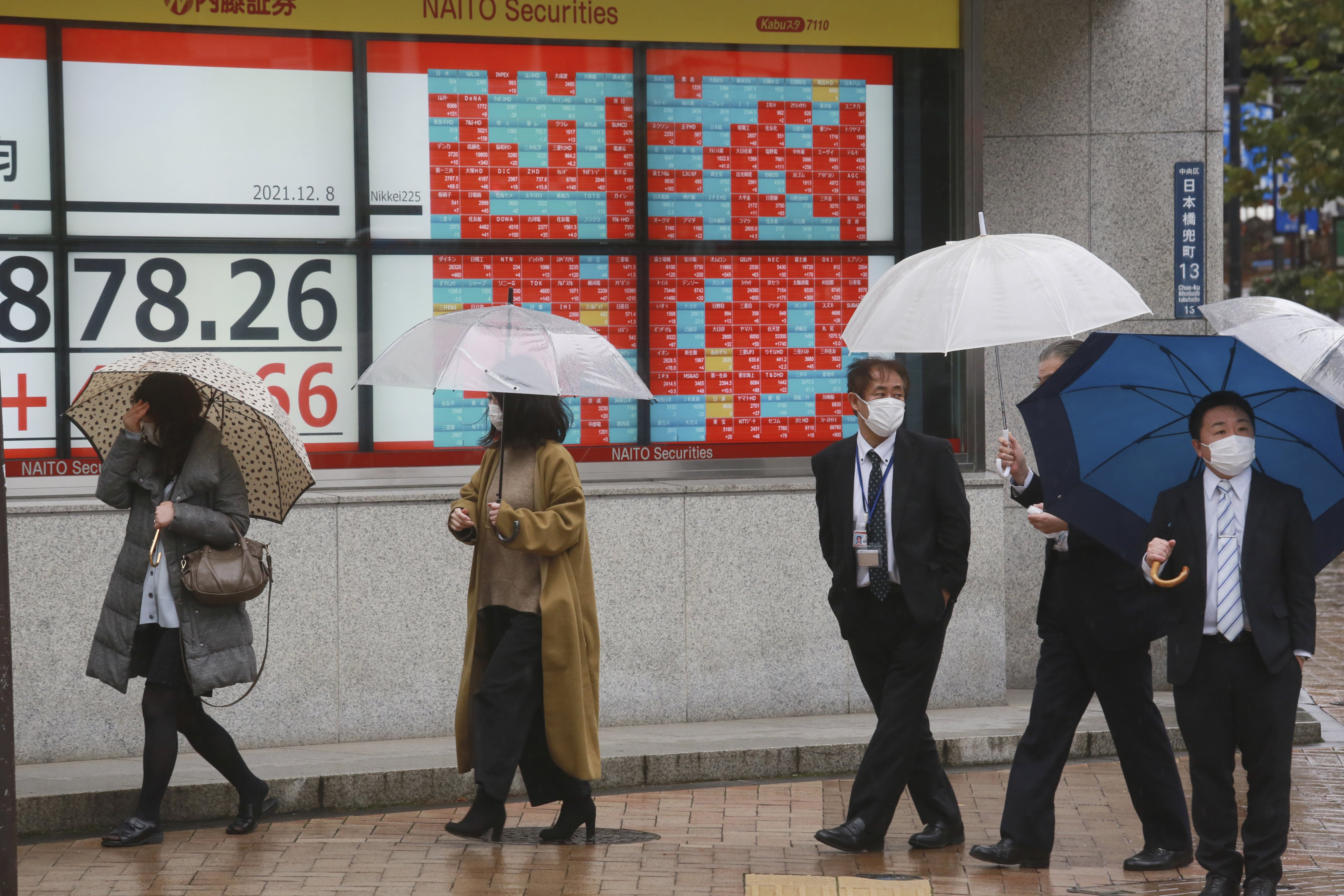 People walk by an electronic stock board of a securities firm in Tokyo. Photo: AP
