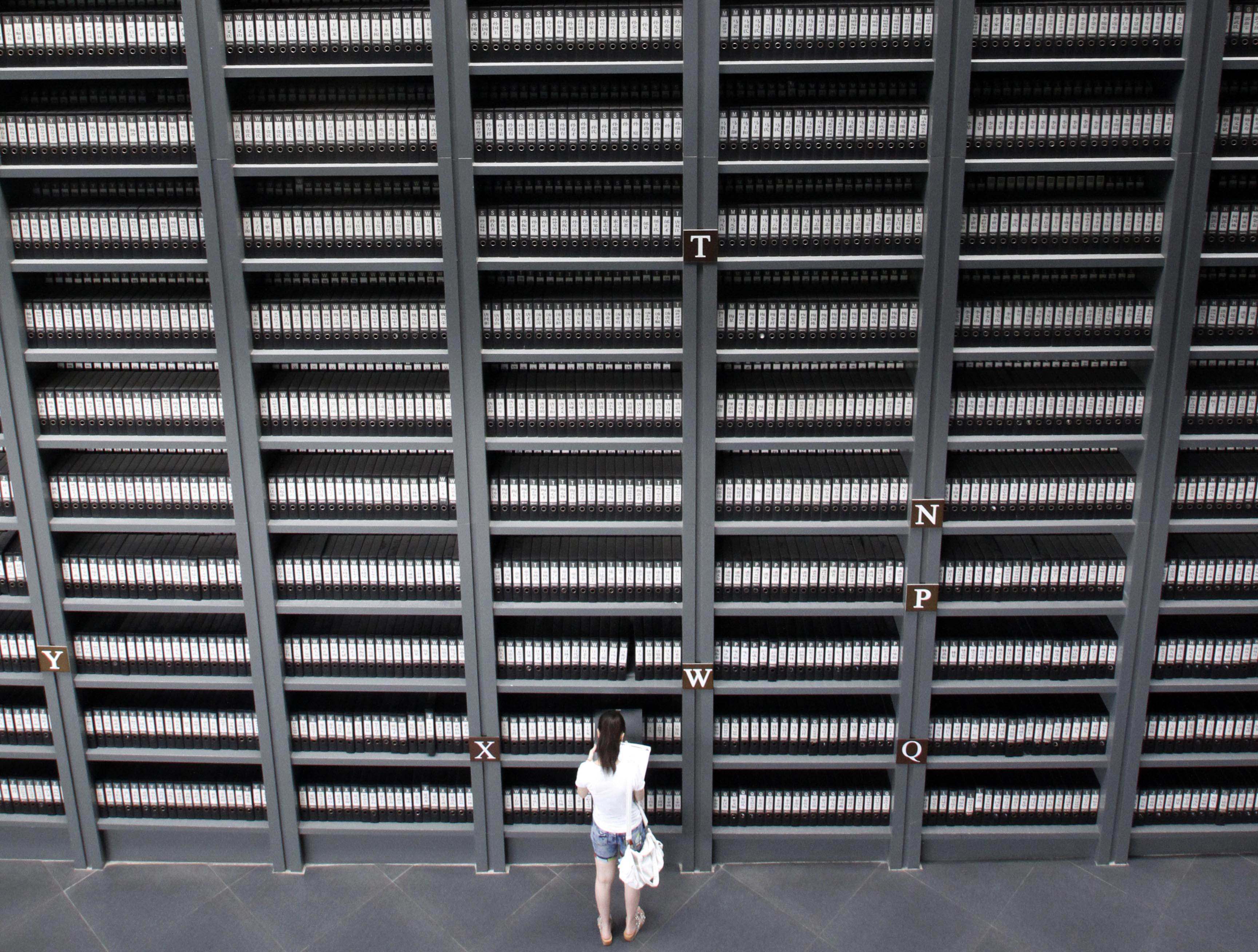 A girl reads files on victims killed during the Nanking massacre at a memorial Hall in Nanjing, Jiangsu province. Photo: AFP