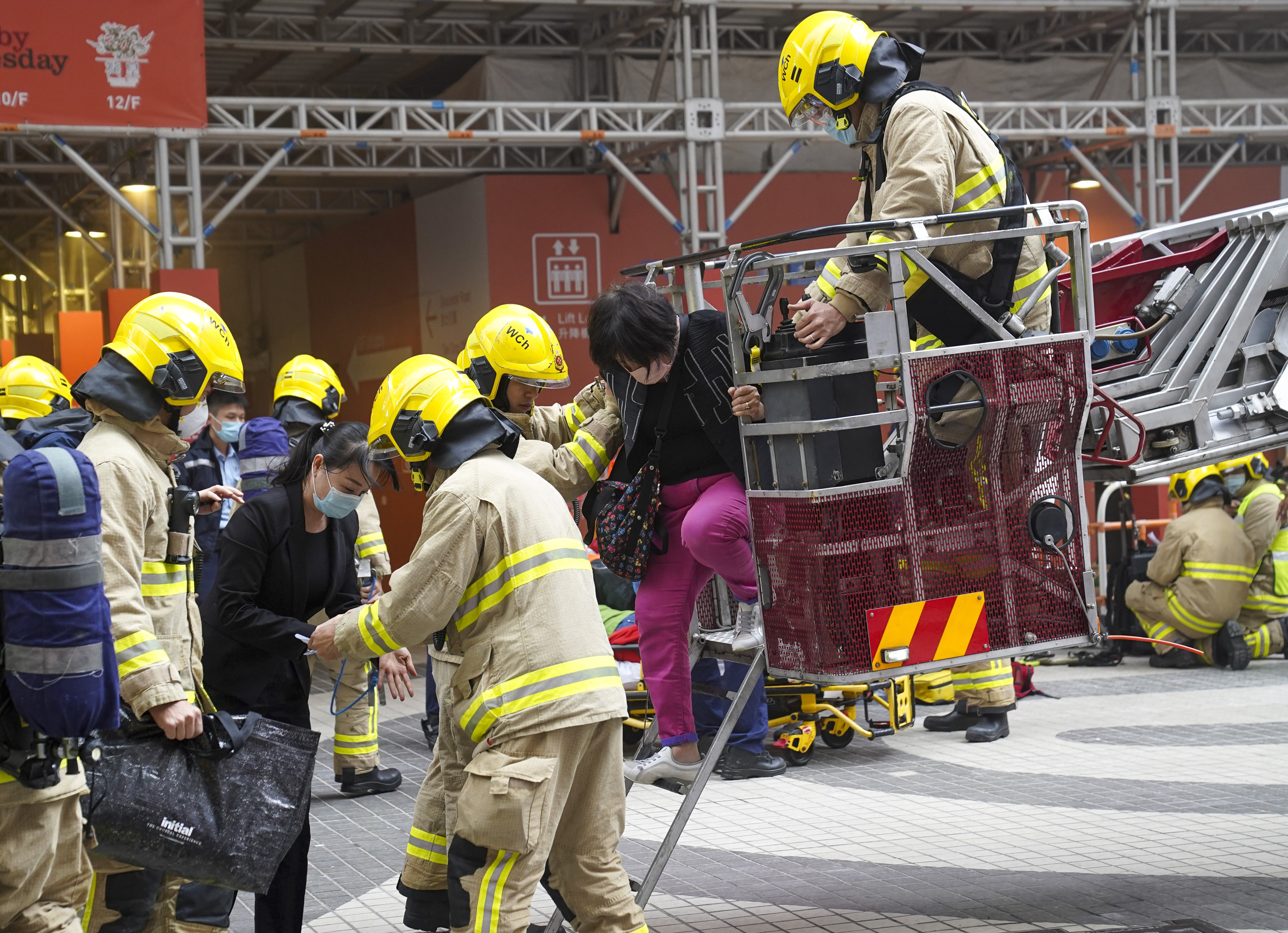 Firefighters help people to safety after the World Trade Centre in Causeway Bay caught fire on Wednesday. Photo: Sam Tsang