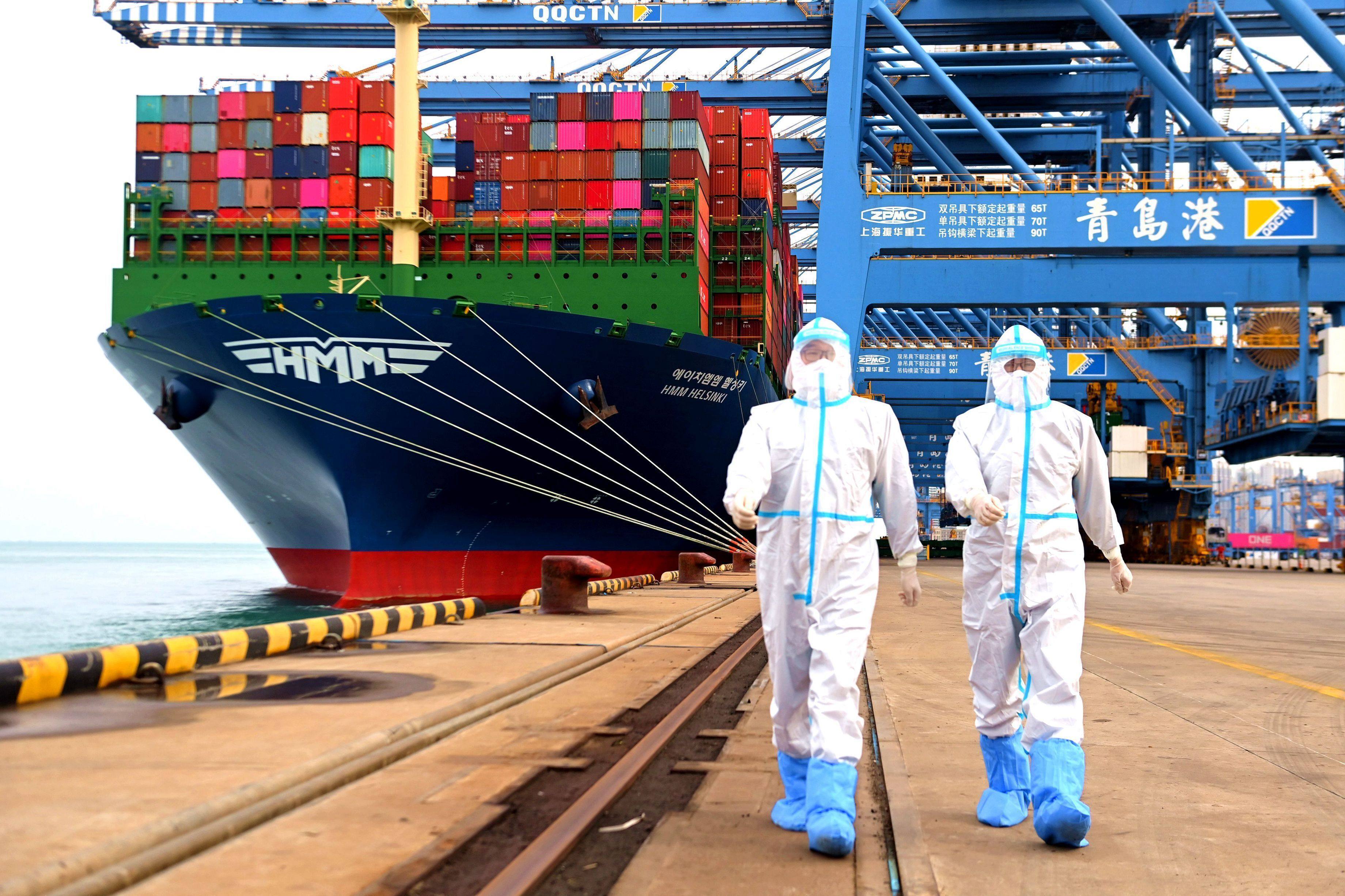 China immigration inspection officials in protective overalls head away from a container ship at a port in Qingdao, in eastern China’s Shandong province, on November 7. Photo: AP