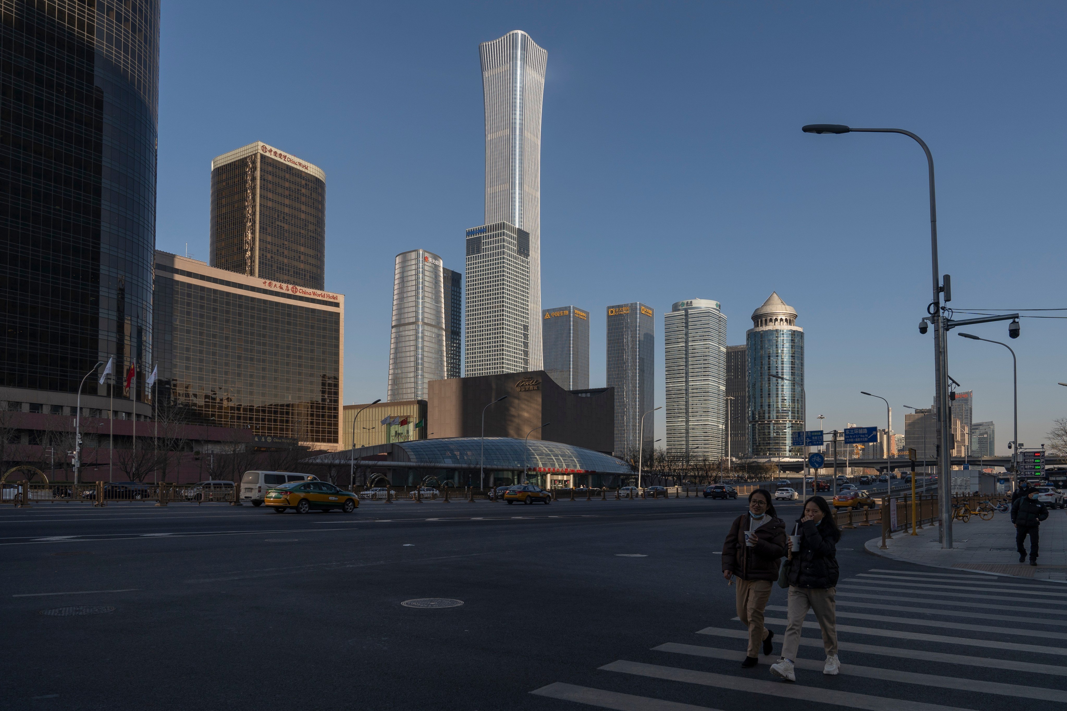Pedestrians cross a road in Beijing on  December 13. The central government has said its key economic goals for the coming year include counteracting growth pressures and stabilising the economy. Photo: Bloomberg