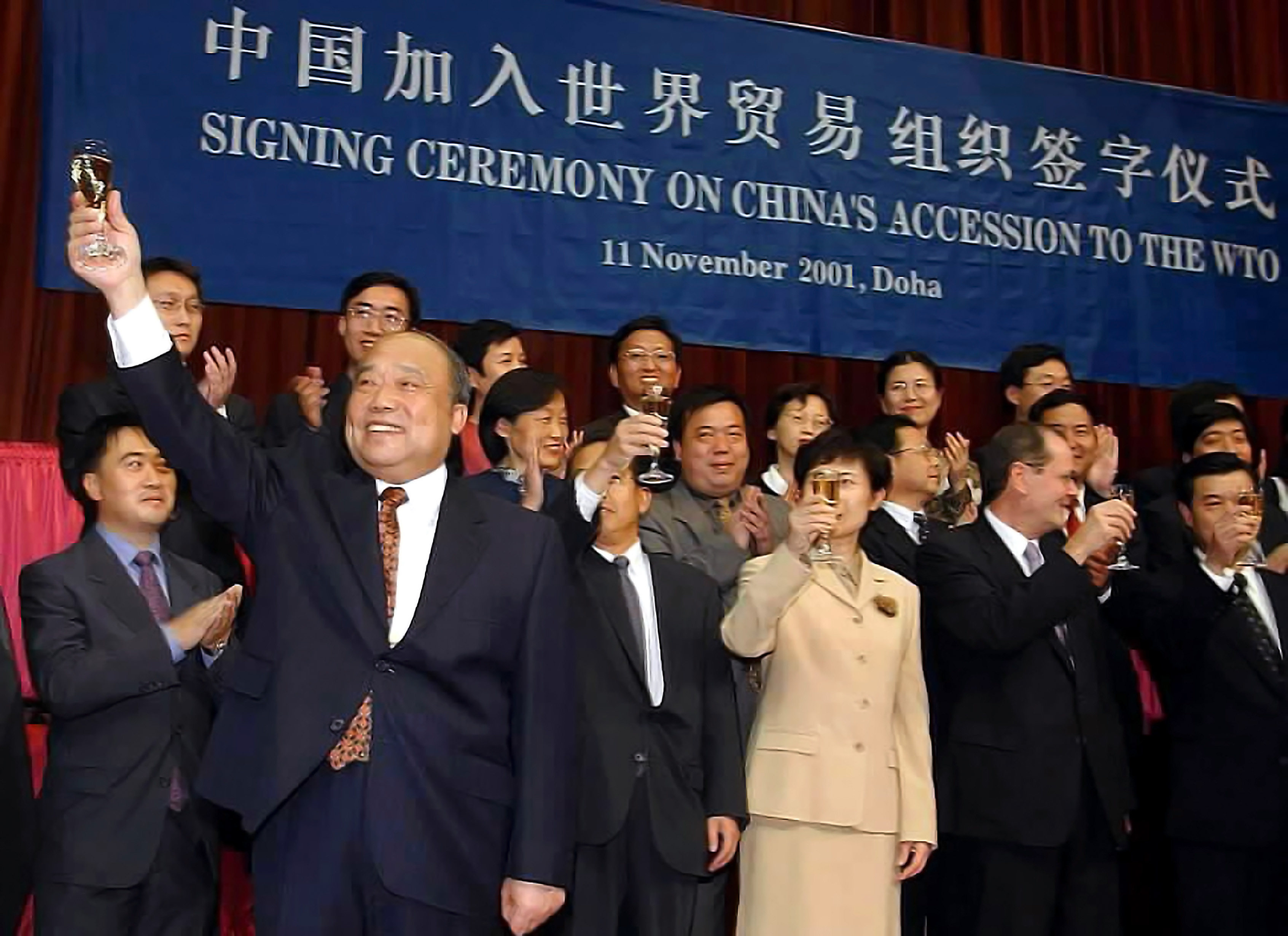 Shi Guangsheng (front left), then Chinese minister of Foreign Trade and Economic Cooperation, celebrates with others after signing the protocol of China’s accession to the World Trade Organization on behalf of the Chinese government, in Doha, Qatar, on November 11, 2001. Photo: Xinhua